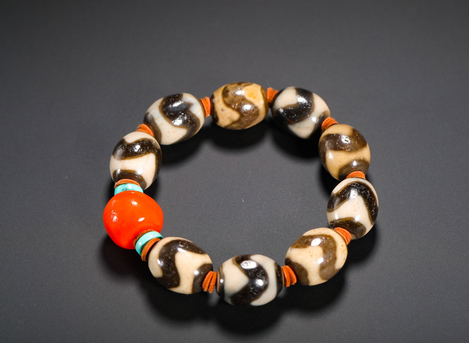 TANG DYNASTY TIGER-TOOTH SKY BEAD BRACELET: DIAMETER:1.6CM (0.63IN) WEIGHT:80G (0.18LB) TIBETAN BRACELET WITH TIGER-TOOTH DZI BEADS, OLD AMBER & TURQUOISE SPACERS. COMPOSED OF NINE OLIVE-SHAPED ANTIQUE TIGER-TOOTH DZI BEADS, MATCHED WITH ONE RO