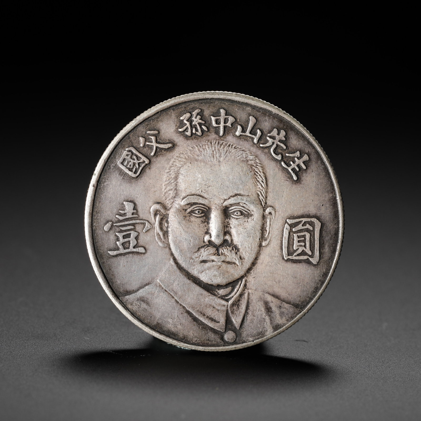 ONE YUAN COMMEMORATIVE COIN OF MR. SUN YAT-SEN, THE FOUNDING FATHER OF THE NATION: D:3.9CM (1.54IN) WEIGHT:27G (0.06LB) THIS SILVER COIN WAS ISSUED TO COMMEMORATE DR. SUN YAT-SEN. THE OBVERSE FEATURES A FRONT-FACING PORTRAIT OF SUN YAT-SEN, WITH THE INSCRIPTION "FATHER OF THE NATION