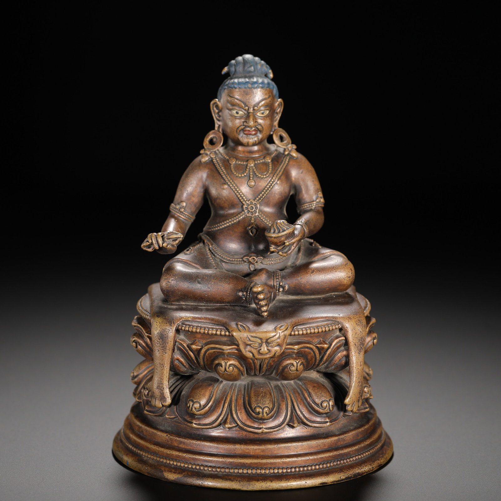 A BRONZE STATUE OF THE YELLOW GOD OF WEALTH FROM THE QING DYNASTY: HEIGHT:13.5CM (5.31IN) WIDTH:9.5CM (3.74IN) WEIGHT:740G (1.63LB) PURPLE COPPER STATUE OF YELLOW JAMBHALA, QING TIBETAN BUDDHISM. SEATED IN FULL LOTUS POSE WITH FIERCE DIGNIFIED FACIAL FEATURES, BLUE-P