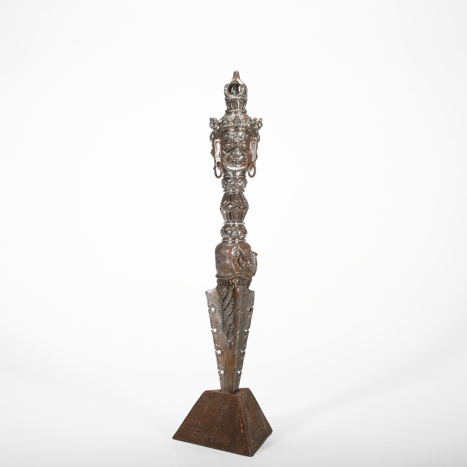 IRON THREE-SIDED MAHAGALA VAJRA PEG OF THE QING DYNASTY: HEIGHT:43CM (16.93IN) WIDTH:12CM (4.72IN) WEIGHT:2410G (5.31LB) IRON PHURBA VAJRA WITH THREE-SIDED MAHAKALA HEADS, QING TIBETAN ESOTERIC BUDDHISM, MATCHED WITH SQUARE IRON BASE. DIVIDED INTO THREE SEC