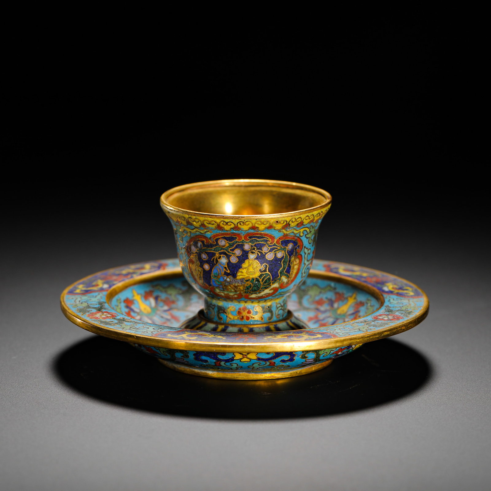 QING DYNASTY QIANLONG GILDED CLOISONNE CUP HOLDER: HEIGHT:6CM (2.36IN) WIDTH:11.5CM (4.53IN) WEIGHT:320G (0.71LB) SET OF GILDED BRONZE CLOISONN? TEA CUP AND SAUCER WITH LANDSCAPE FIGURE MOTIF, QIANLONG REIGN OF QING DYNASTY. BRONZE CORE, THE INNER CUP