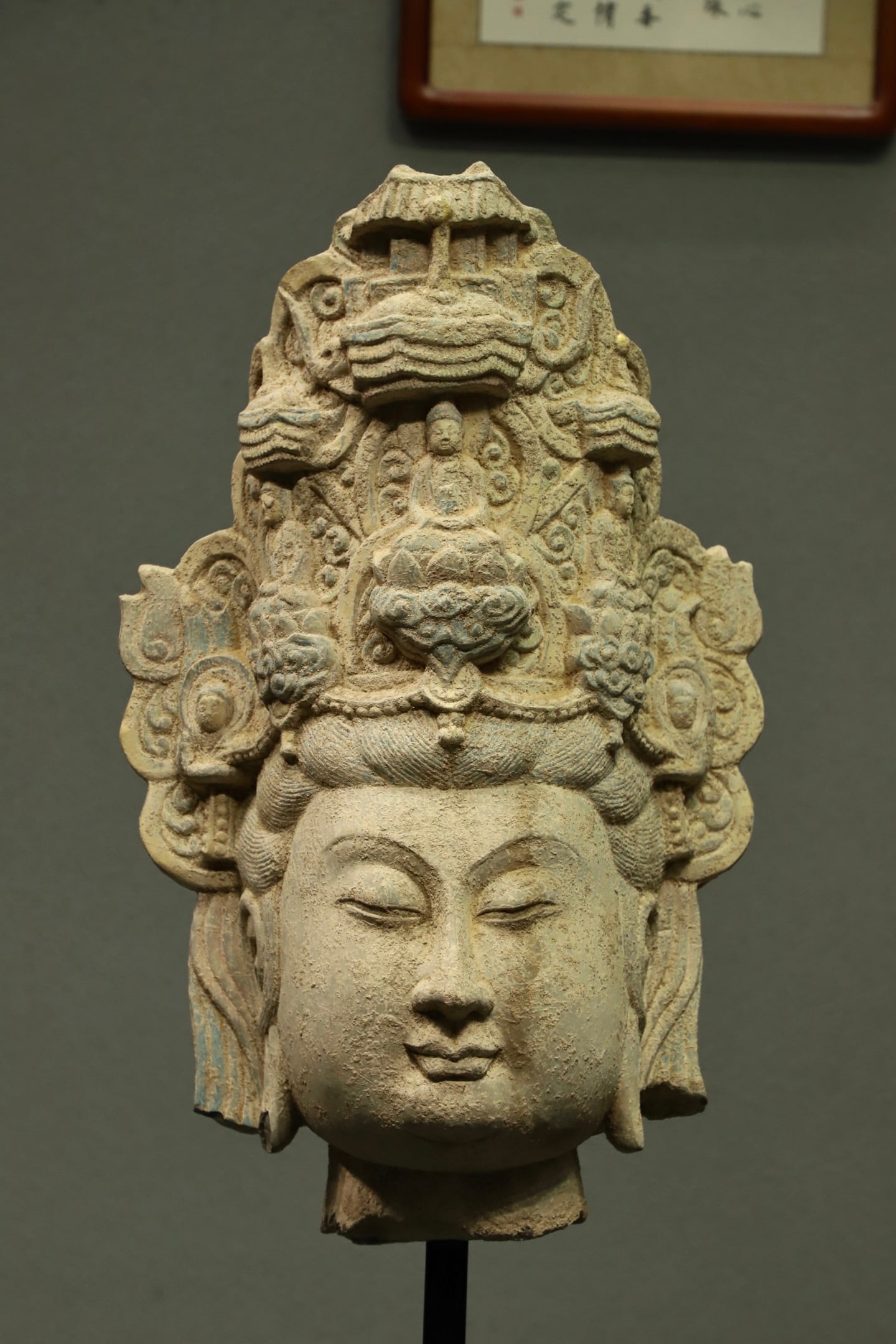 THE STONE HEAD OF GUANYIN IN THE SONG DYNASTY: H:96CMH:65CM THIS IS AN ANCIENT STONE-CARVED HEAD OF GUANYIN BODHISATTVA, FEATURING AN ELABORATE CROWN WITH A MINIATURE BUDDHA AND A PAVILION CARVING AT ITS CENTER, AND A SERENE, COMPASSIONATE EXPRESS