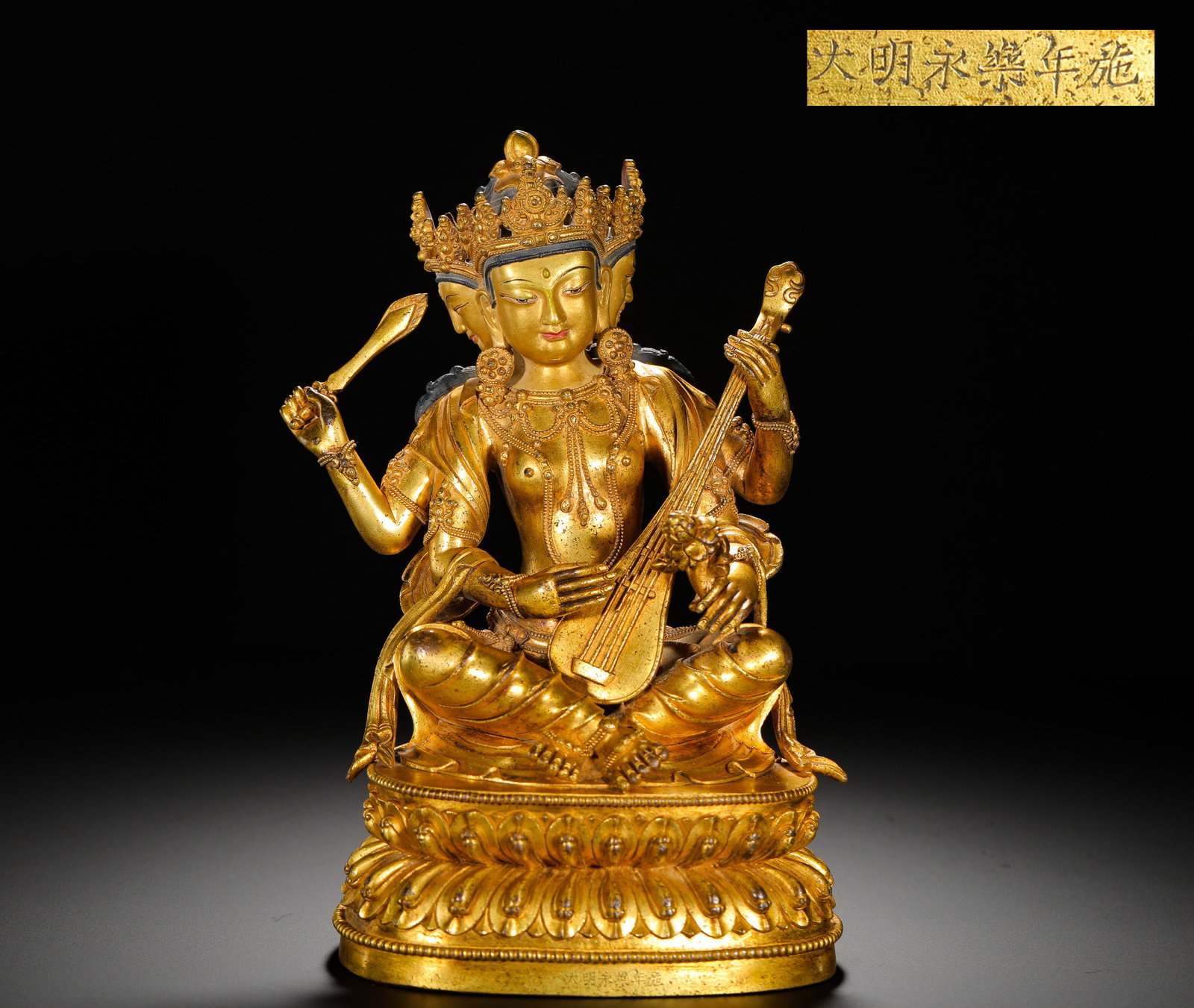 A GILDED BRONZE STATUE OF THE GODDESS OF MELODIOUS SOUNDS FROM YONGLE OF THE MING DYNASTY: HEIGHT:24CM (9.45IN) WIDTH:14CM (5.51IN) WEIGHT:2890G (6.37LB) IMPERIAL FULLY GILDED COPPER STATUE OF SARASWATI, YONGLE REIGN OF MING DYNASTY. DOUBLE-HEADED FORM WITH ELABORATE FIVE-LEAF JEWELED CROWN