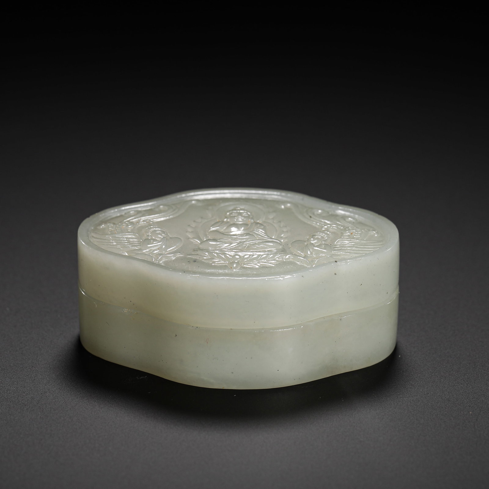 QING DYNASTY HETIAN JADE BUDDHA PATTERN FLOWER-SHAPED SEAL PASTE BOX: HEIGHT:2.5CM (0.98IN) WIDTH:6.3CM (2.48IN) WEIGHT:50G (0.11LB) HETIAN PALE WHITE JADE FLOWER-SHAPED CINNABAR PASTE BOX WITH BUDDHA CARVING, QING DYNASTY.HOLLOW-CARVED FROM A SINGLE JADE BLOCK INTO PET