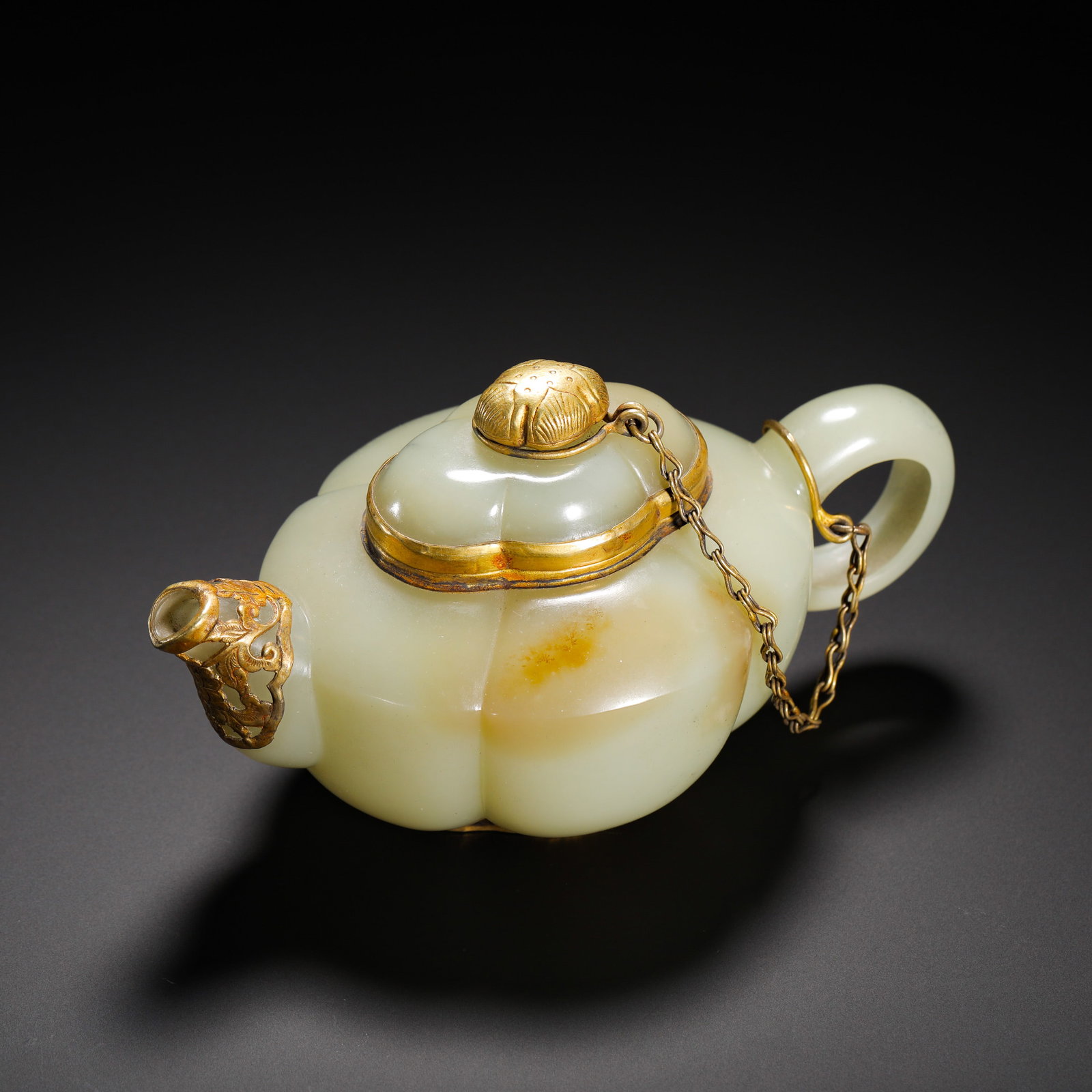 QING DYNASTY HETIAN JADE TEAPOT: HEIGHT:8CM (3.15IN) WIDTH:14CM (5.51IN) WEIGHT:190G (0.42LB) HETIAN WHITE JADE MELON-FORM TEAPOT WITH GOLD MOUNTING, QING DYNASTY.CREAMY MILD WHITE JADE WITH NATURAL CONCENTRATED YELLOW RUSSET PATINA.