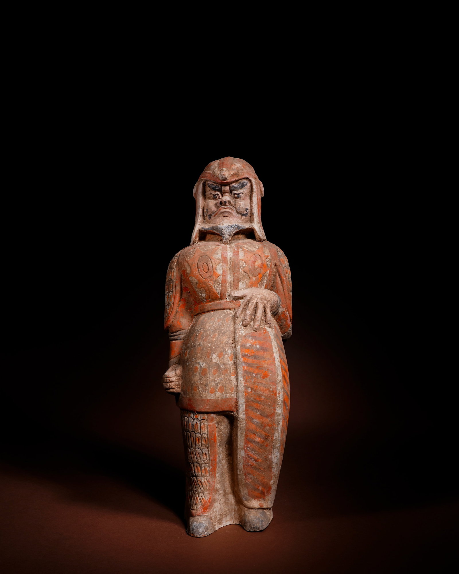PAINTED POTTERY FIGURINES OF SHIELD-HOLDING WARRIORS FROM THE NORTHERN DYNASTIES: L:13.5cm H:41cm This painted pottery warrior figurine of Northern Dynasties is molded in separate grey clay pieces then assembled, fully decorated with cinnabar red mineral pigments.The warrior wears 