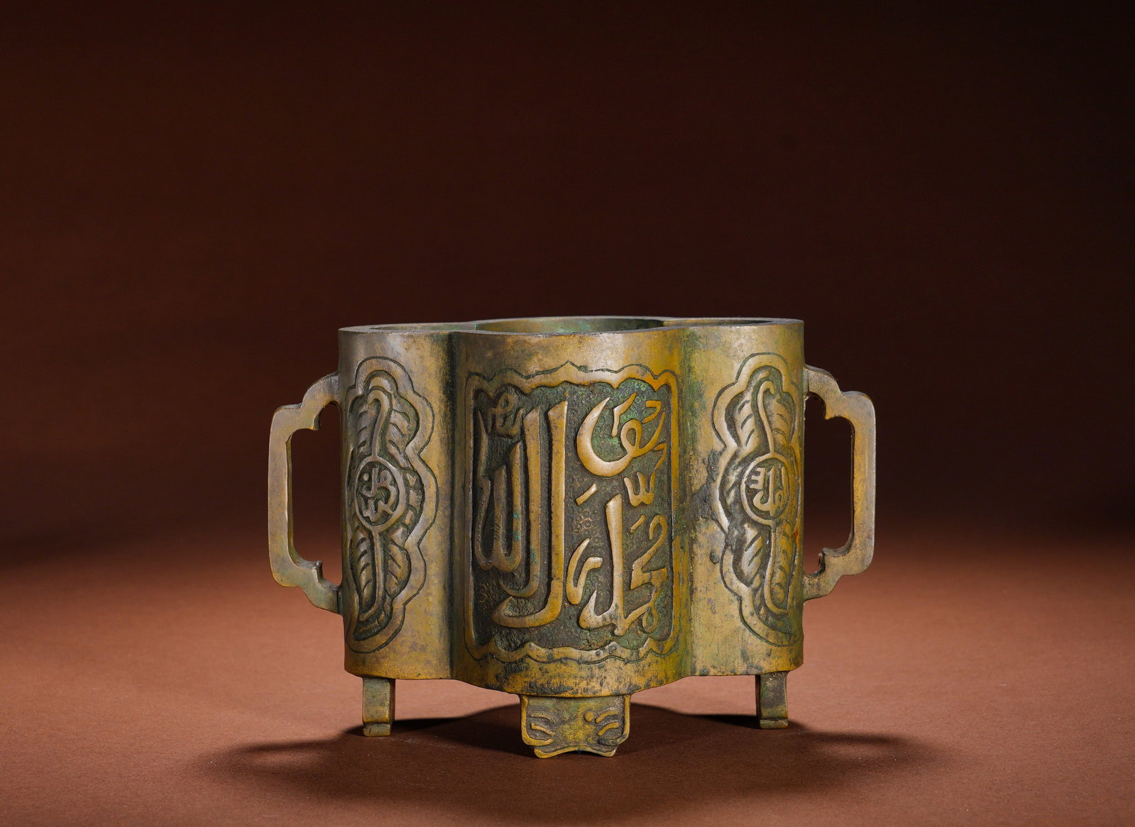 MING DYNASTY COPPER ARABIC DOUBLE-EARED FURNACE: Height:11cm Width:16cm Weight:1900gBronze Begonia-shaped Three-legged Censer with Arabic Inscriptions and Double Handles, an Islamic-style Xuande censer. Cast from refined copper, it boasts a begonia 