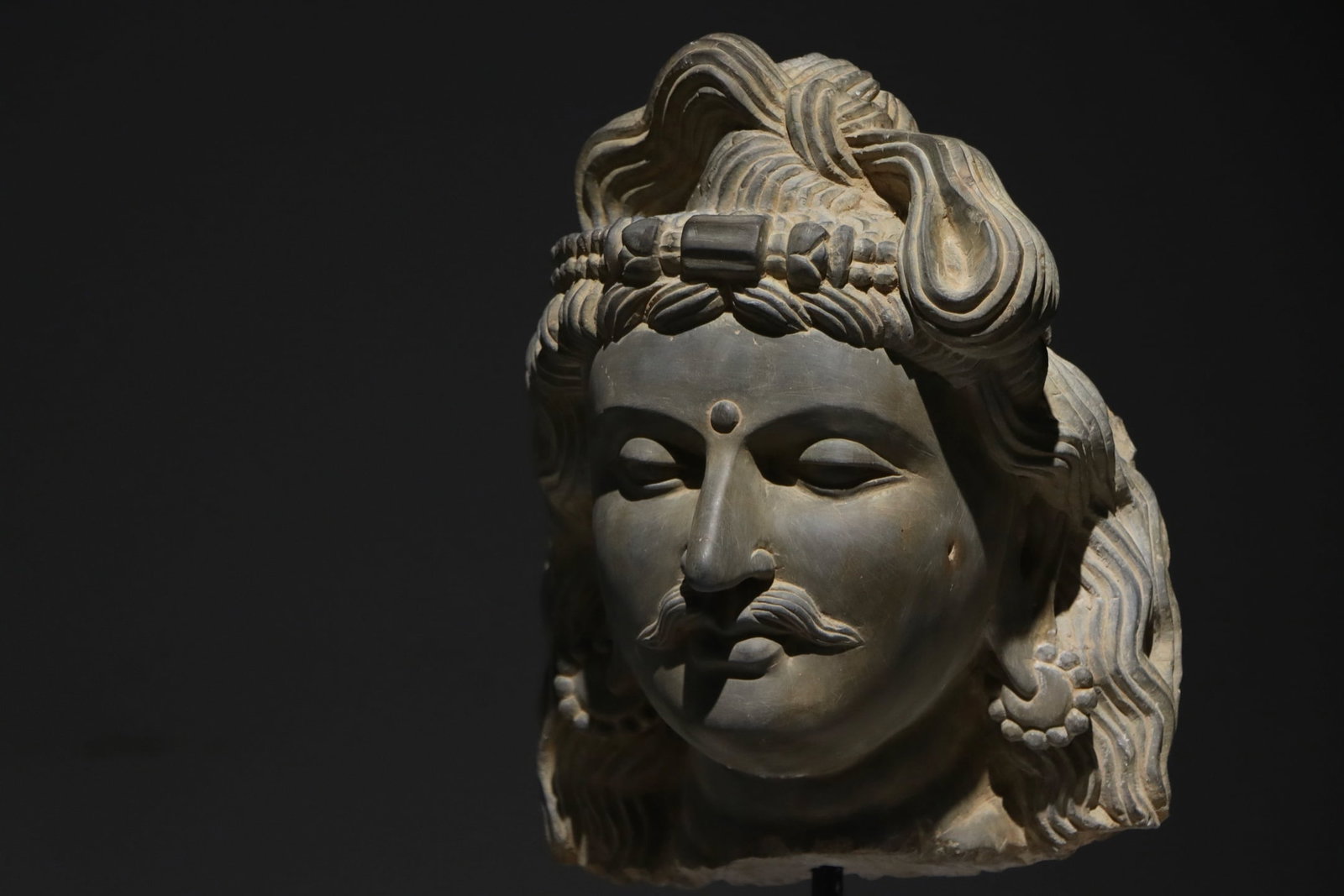 GANDHARA STATUES FROM THE 3RD CENTURY: H:53cm H:31cm This is a stone bust of a Bodhisattva in Gandhara style, with a realistic face, slender eyebrows and eyes, a crowned topknot, and wavy curly hair. It integrates Greco-Roman realistic tec