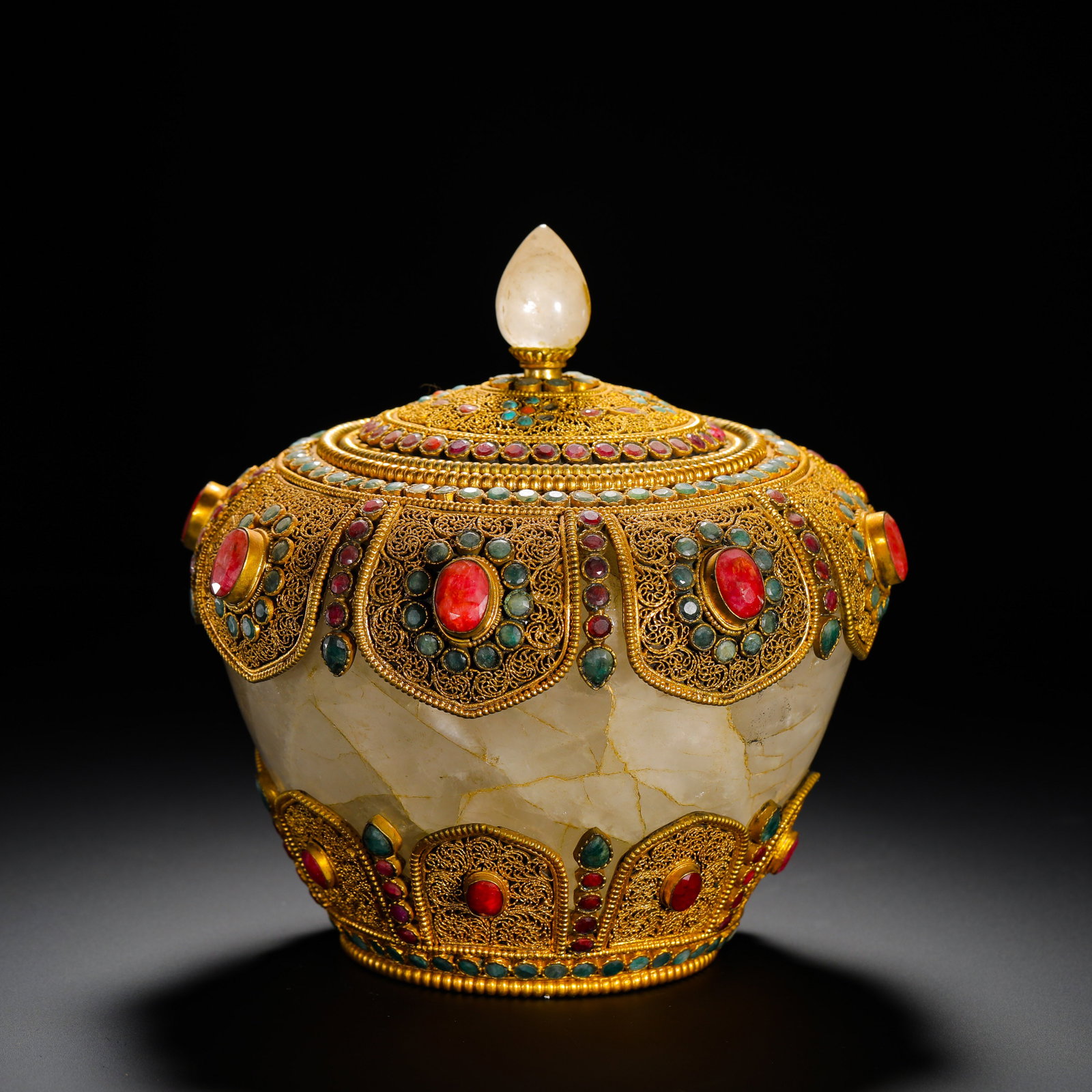 A QING DYNASTY CRYSTAL FILIGREE GILDED INLAID TREASURE OFFERING JAR: Height:17cm (6.69in) Width:17cm (6.69in) Weight:2850g(6.28lb)Tibetan Buddhist offering jar of natural crystal with gilded silver filigree and inlaid gemstones, Qing Dynasty.The jar body is hollowed fr