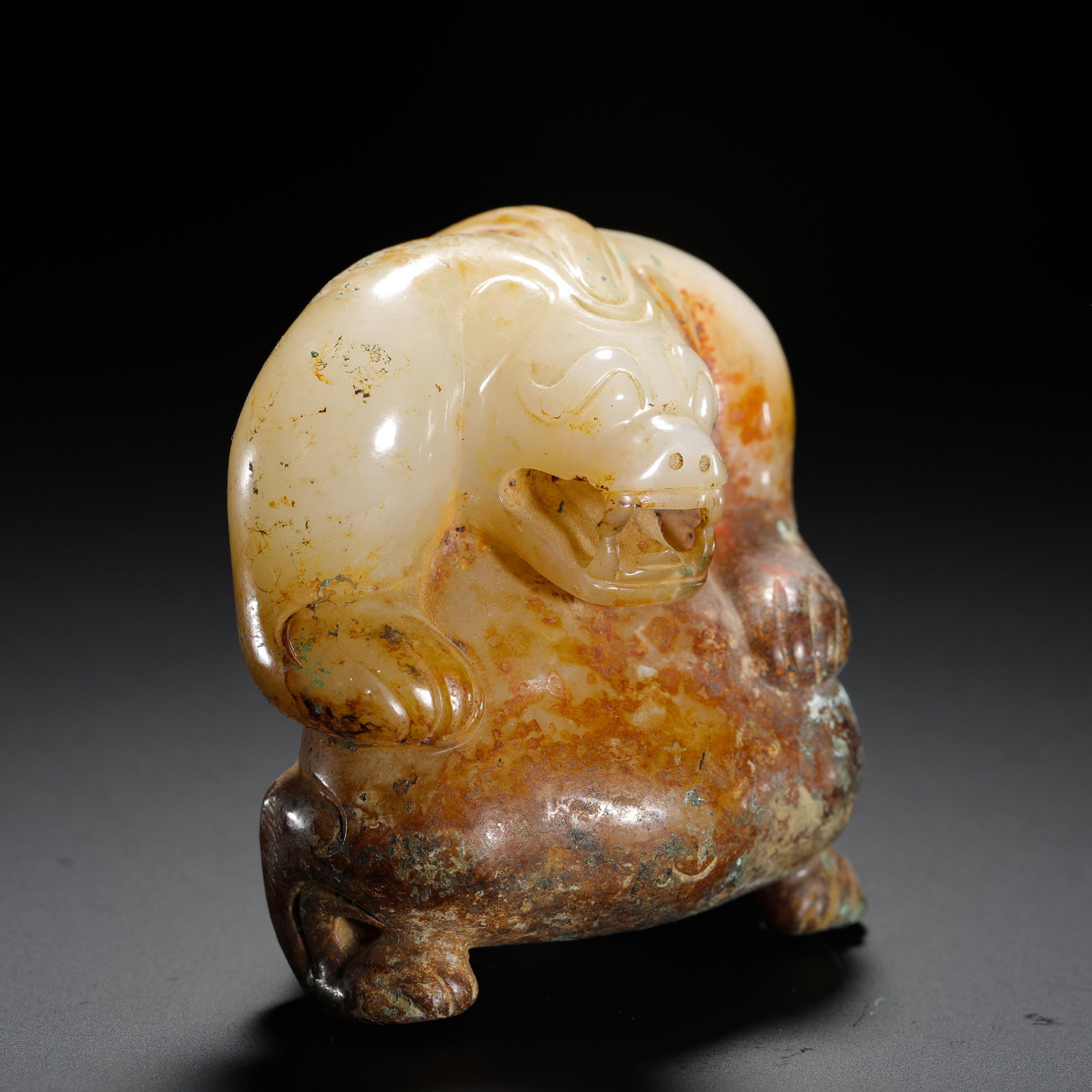 HAN DYNASTY HETIAN JADE AUSPICIOUS BEAST: H:7.5cm W:6cm Weight:290g A Han Dynasty round-carved jade beast with varied natural patina, an antique jade ornament for warding off evil