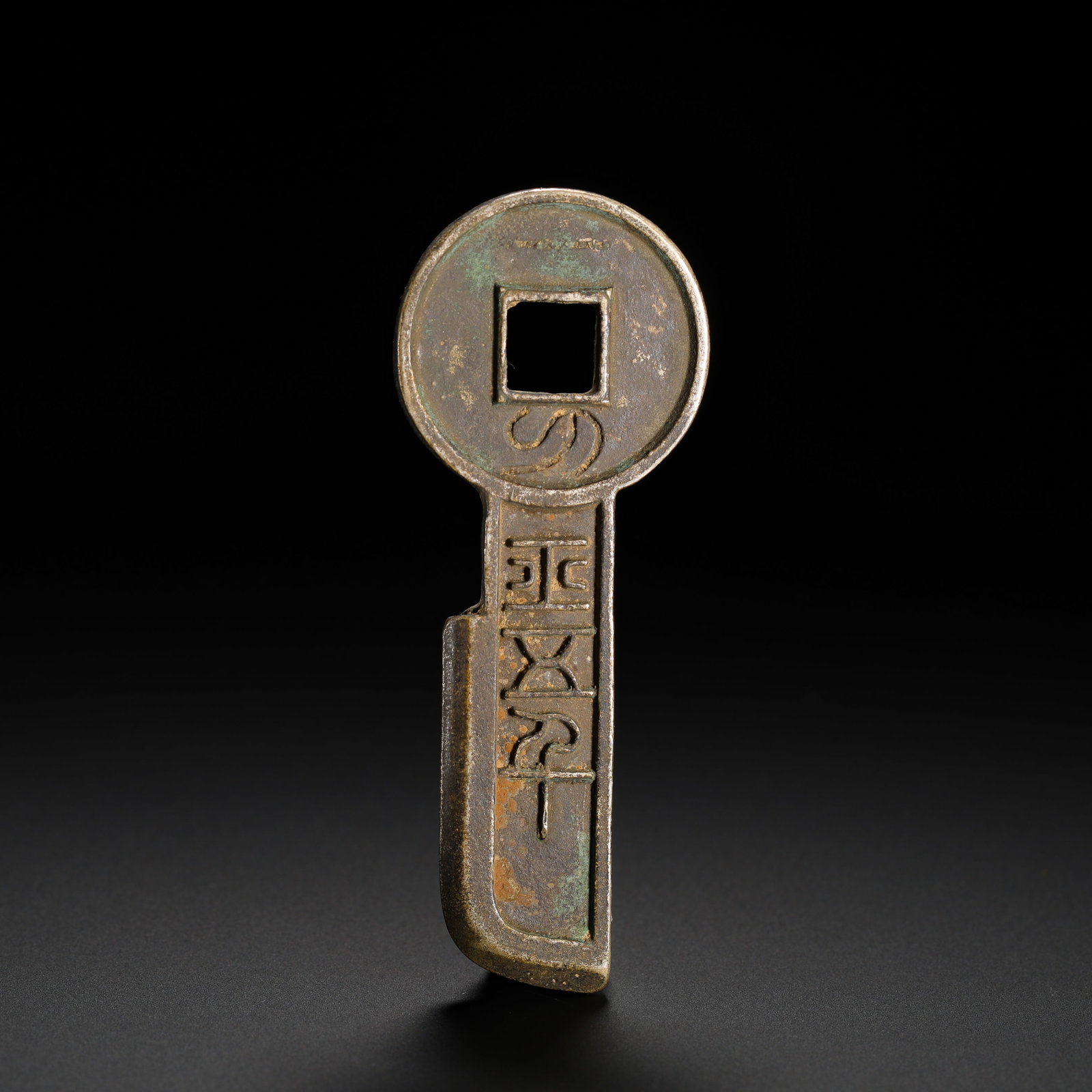FIVE HUNDRED COINS OF SILVER CONTRACT KNIFE FROM THE HAN DYNASTY: Height:7.5cm (2.95in) Width:2.9cm (1.14in) Weight:32g(0.07lb)Silver "Qi Dao Wu Bai" knife coin, Xinmang Dynasty. Classic key-shaped form with square-hole round ring and blade below. The ring is carved