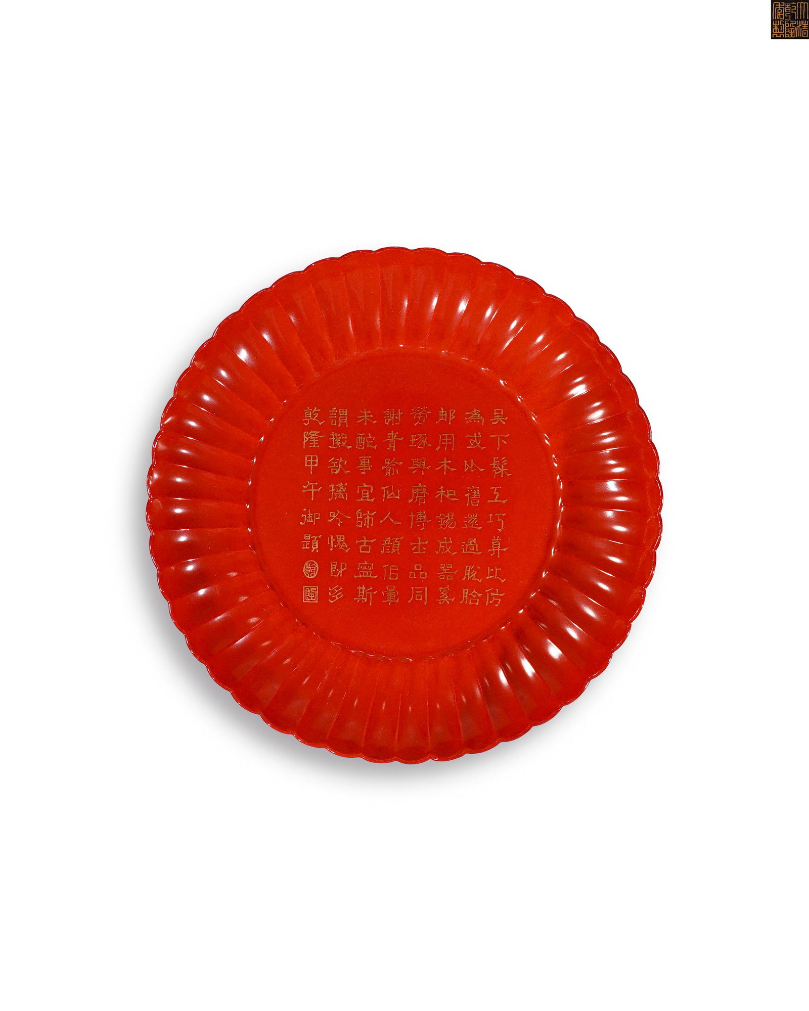 QING DYNASTY QIANLONG CORAL RED GLAZE IMITATION VERMILION LACQUER GILDED IMPERIAL POEM PATTERN: D:17.5cm H:3.5cm This is an imperial chrysanthemum-shaped dish from the Qianlong reign of Qing Dynasty, with fluted petal rim and radiating ribbed walls. The whole vessel is covered with even bright i