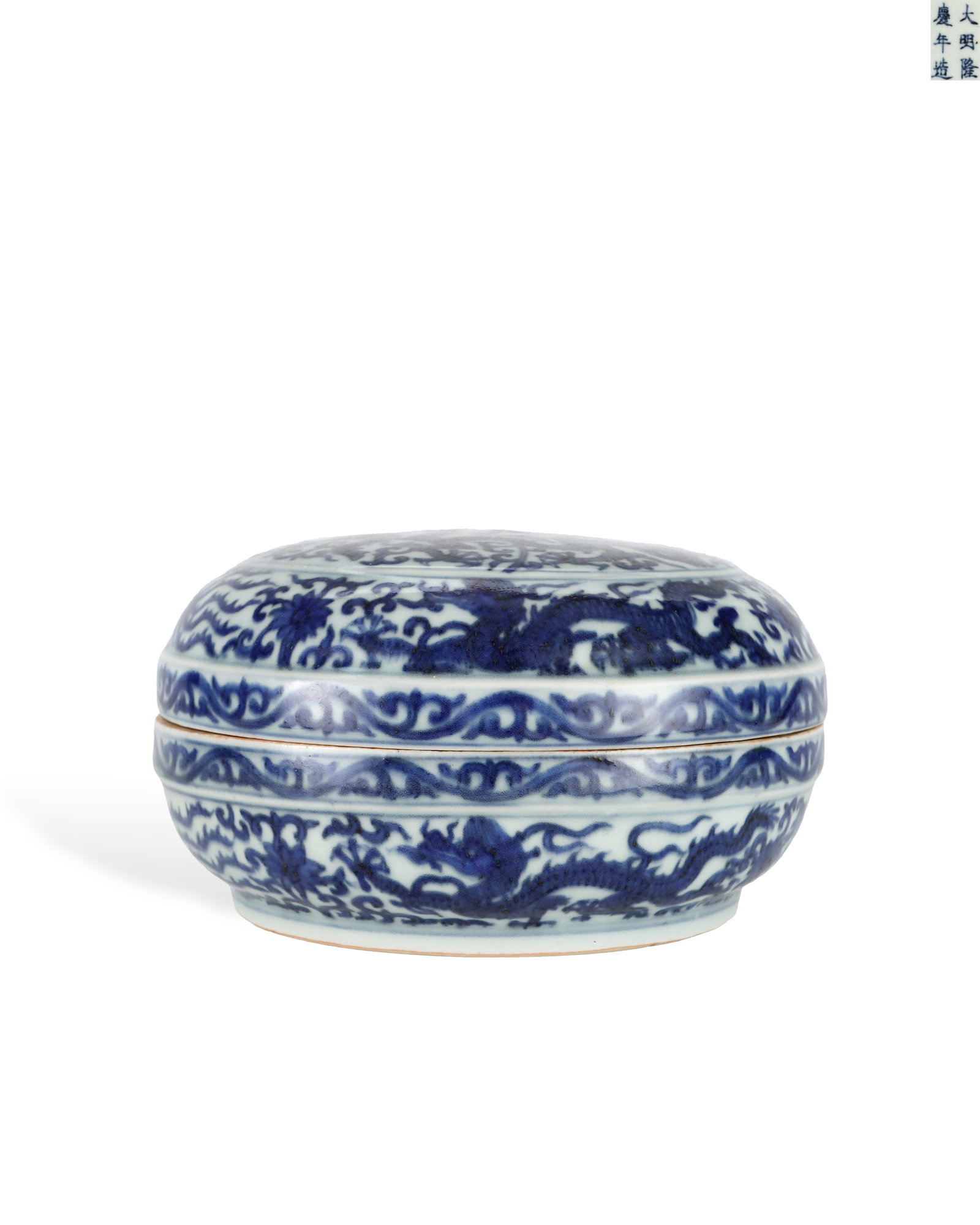 MING DYNASTY LONGQING BLUE AND WHITE COILED DRAGON PATTERN ROUND BOUQUET BOX: H:10.3cm W:18cm This is an imperial blue-and-white lidded box fired in the Longqing reign of Ming Dynasty with fitted lid and base. It has smooth white glaze, fully decorated with patterns painted wit