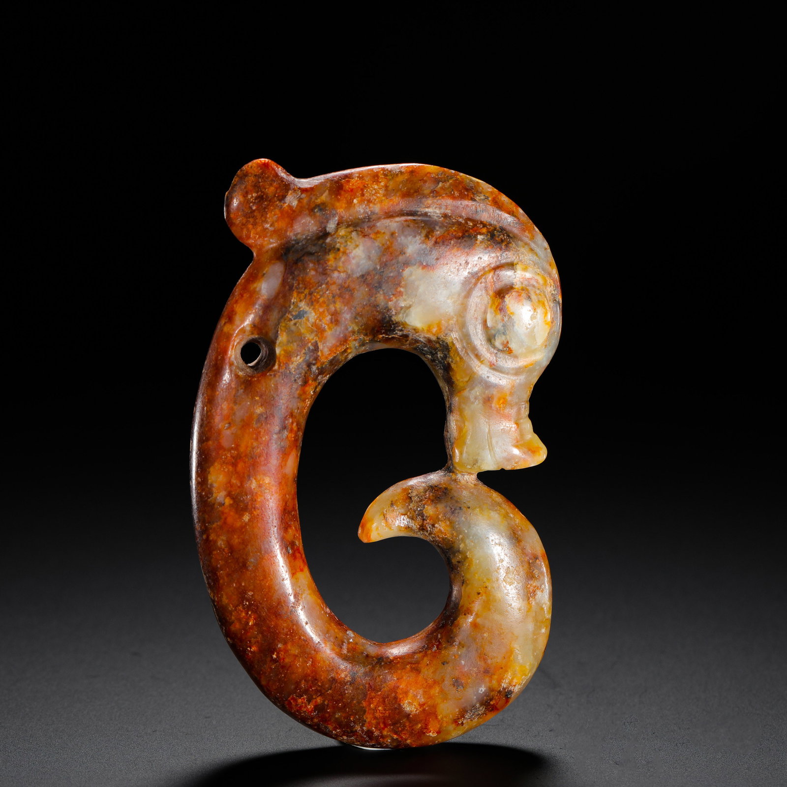 RED MOUNTAIN CULTURE JADE DRAGON: H:9cm W:5.5cm Weight:90g Classic Hongshan C-shaped jade dragon covered in reddish patina, an ancient ritual jade for spiritual worship.