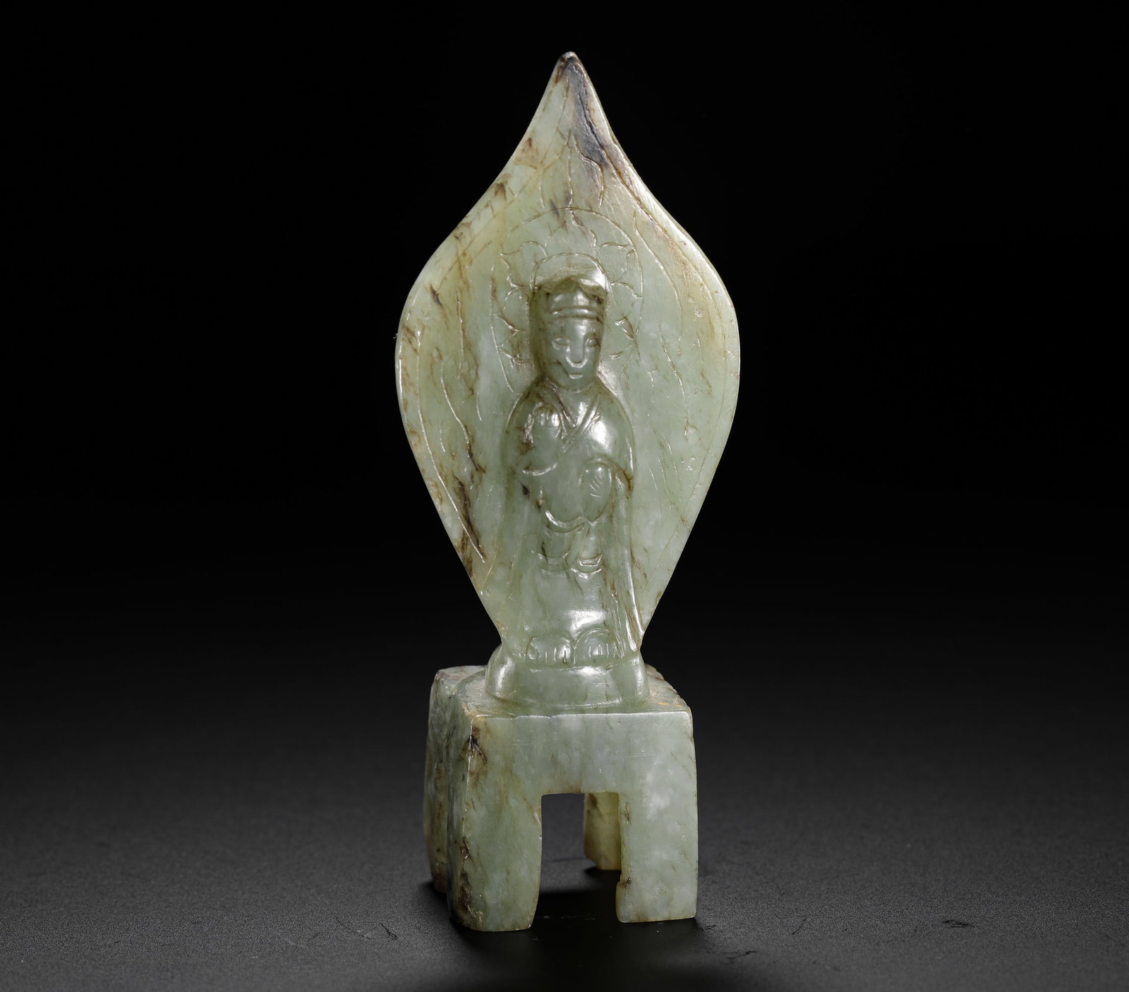 WEI AND JIN HETIAN JADE BUDDHA: H:9.5cm W:2.6cm Weight:60g Wei-Jin jade Buddha carving with peach-shaped aureole and square stand, marked by ancient patina, an early Buddhist jade relic.