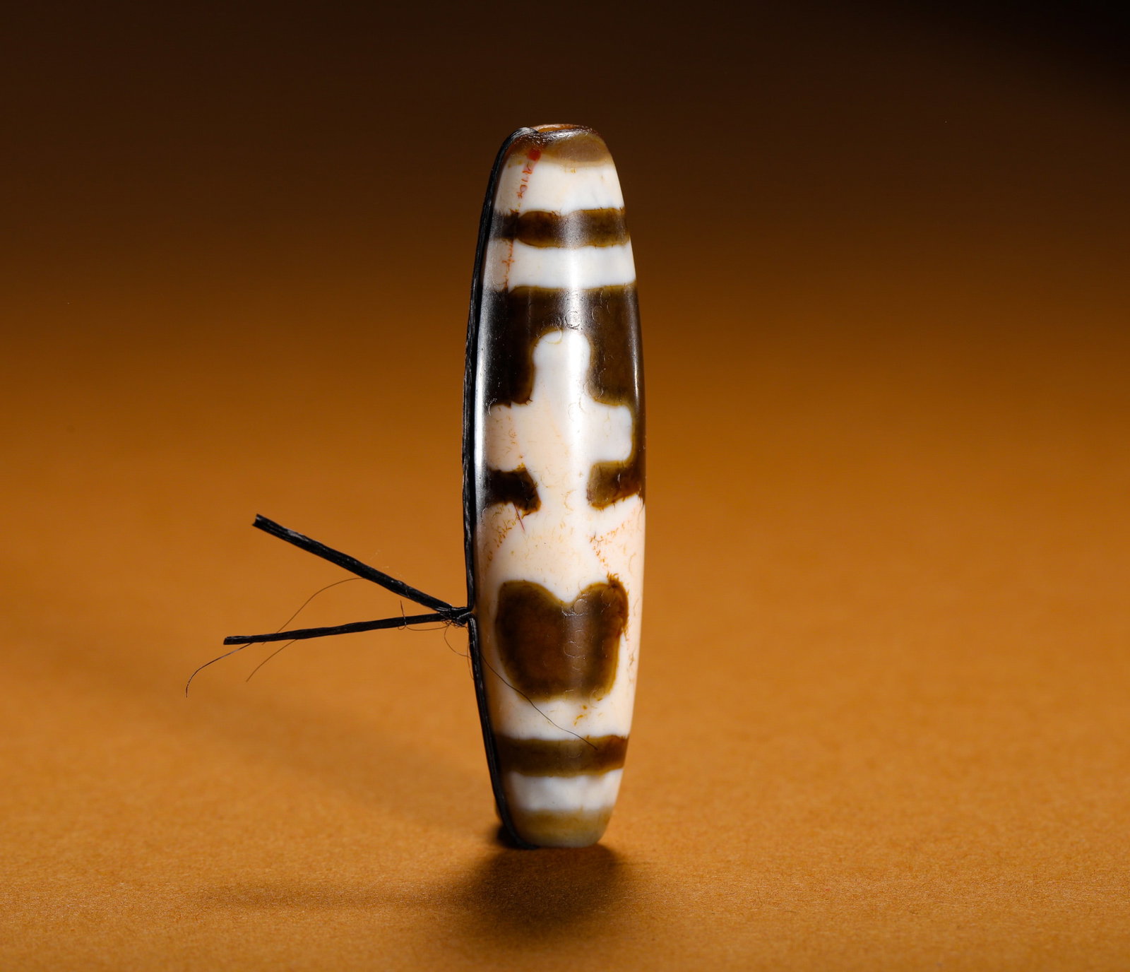 ANCIENT VAJRA BEADS: Height:5.3cm (2.09in)Weight:10g(0.02lb)Ancientagatedzibeadwithsacredvasemotif.Elongatedovalshapewithdistinctblack-whiteagedpatina, thecentralengravingdepictsatreasurevase, flankedbyhorizontalstripeban
