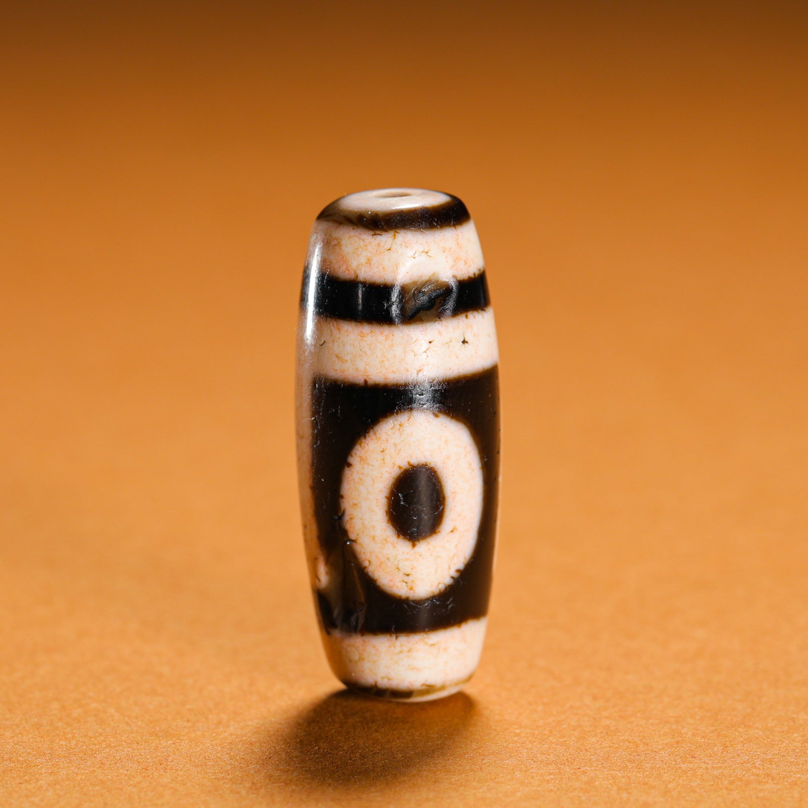ONE GLANCE AT THE SKY PEARL: Height:3.2cm (1.26in)Weight:10g(0.02lb)One-eyeheaven-earthdzibead, TibetanBuddhismetchedagatecraft.Elongatedoliveshapewithsharpblack-whitepatterns, coveredinfinenaturalweatheringtextureandtinycinnabar