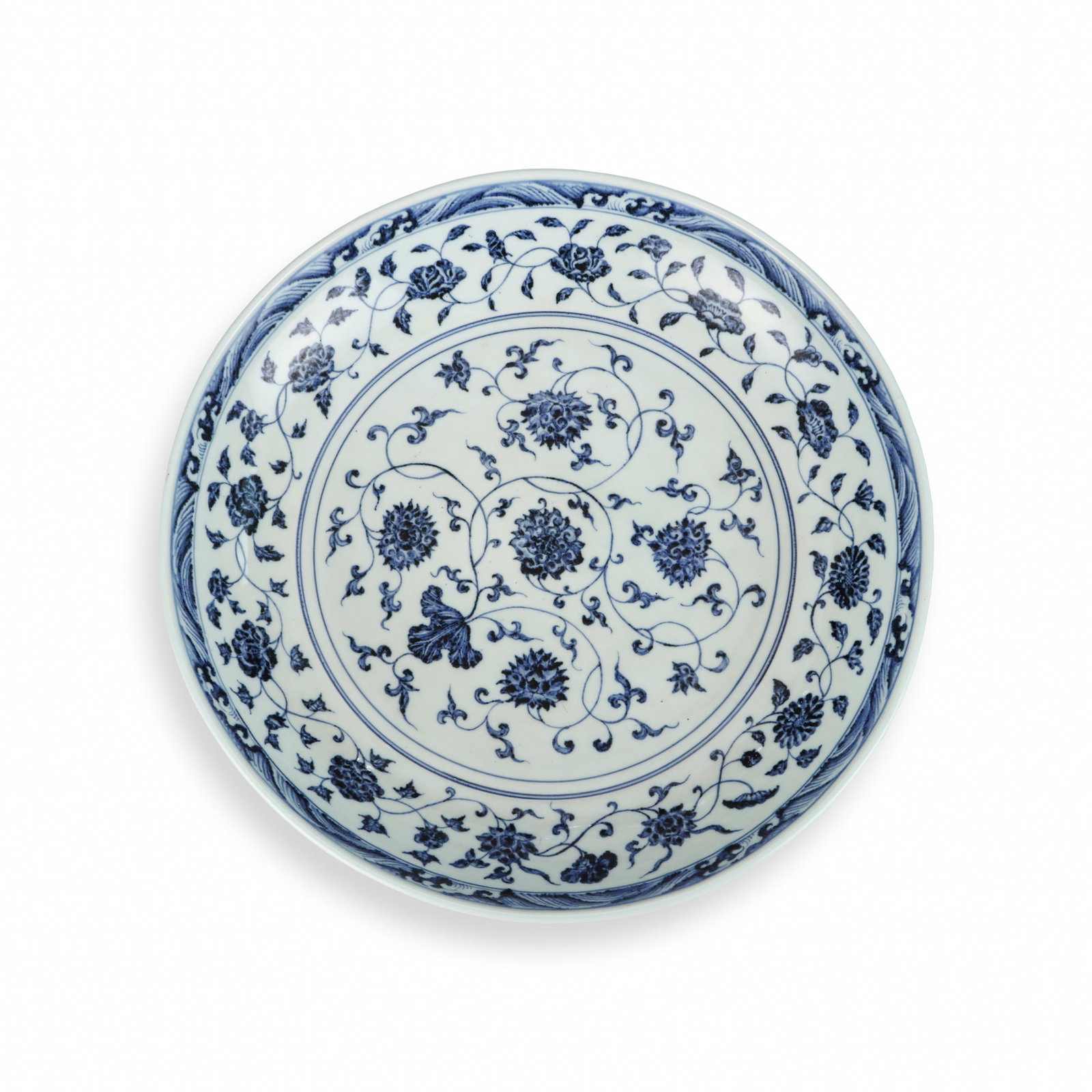 A LARGE PLATE OF BLUE AND WHITE PORCELAIN WITH FLORAL PATTERNS FROM YONGLE OF THE MING DYNASTY: H:7cm W:37.8cm This is an imperial blue-and-white display plate with fine smooth white glaze. Interlocking lotus flowers are painted within double blue circles at the center, the inner wall is covered