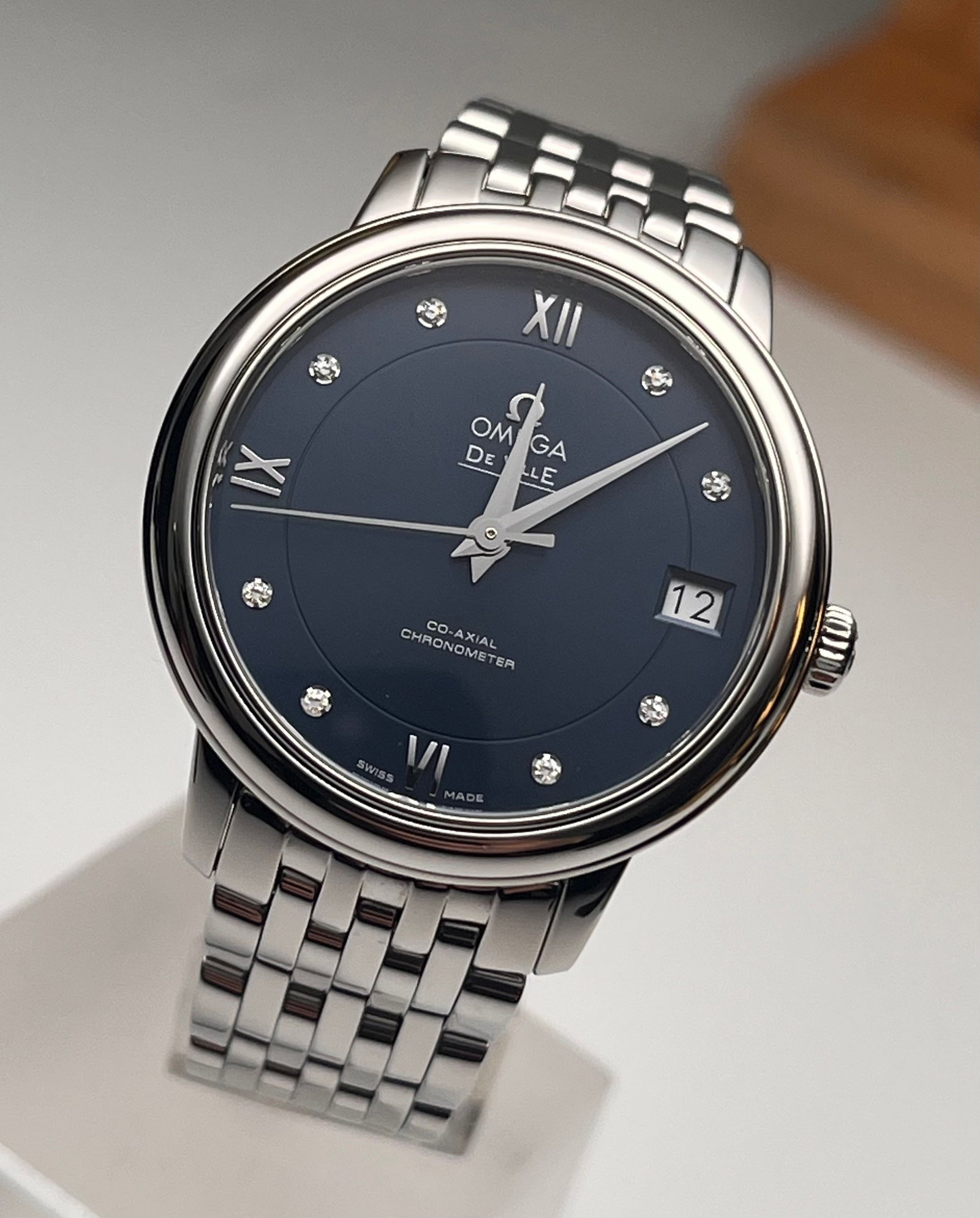 OMEGA DE VILLE WATCHES: Omega De Ville 424.10.33.20.53.001 Women's Automatic Mechanical Watch, 32.7 mm stainless steel case with matching bracelet, deep blue dial featuring diamond-set hour markers and Roman numerals, date d