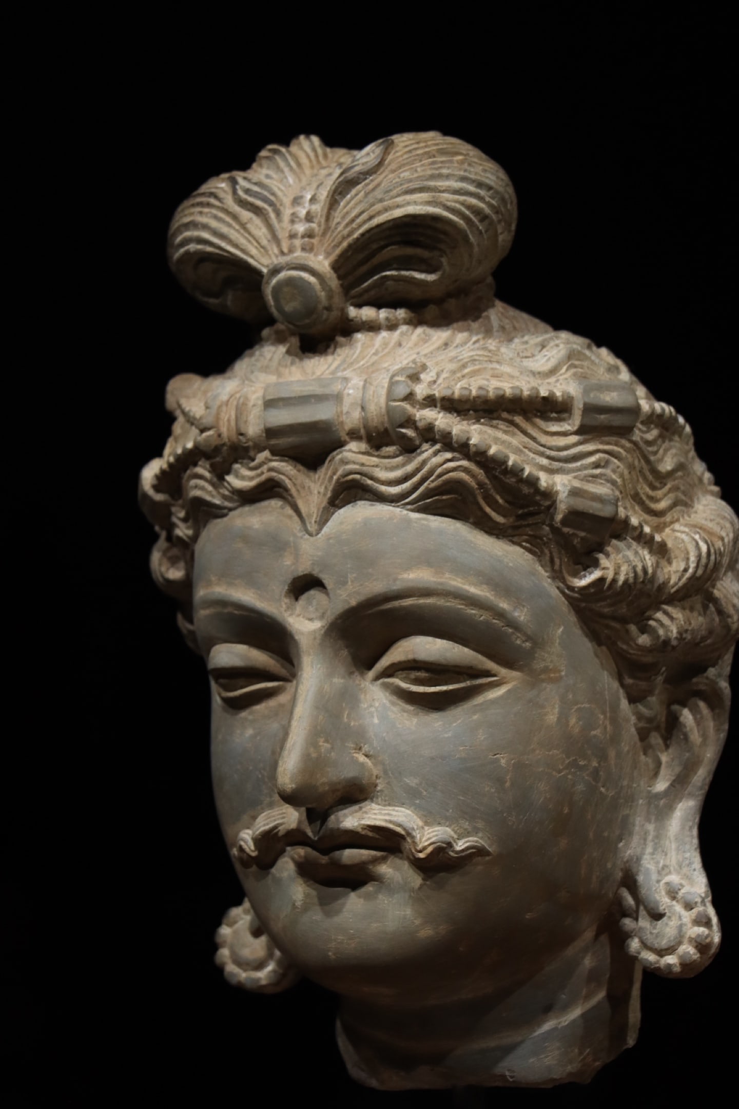 3RD CENTURY GANDHARA BUDDHA'S HEAD: H:47cm H:35cm This is a Gandhara-style stone Bodhisattva head sculpture, adorned with an ornate crown and topknot, featuring an urna (cranial protuberance) on the forehead and a curled mustache, repre