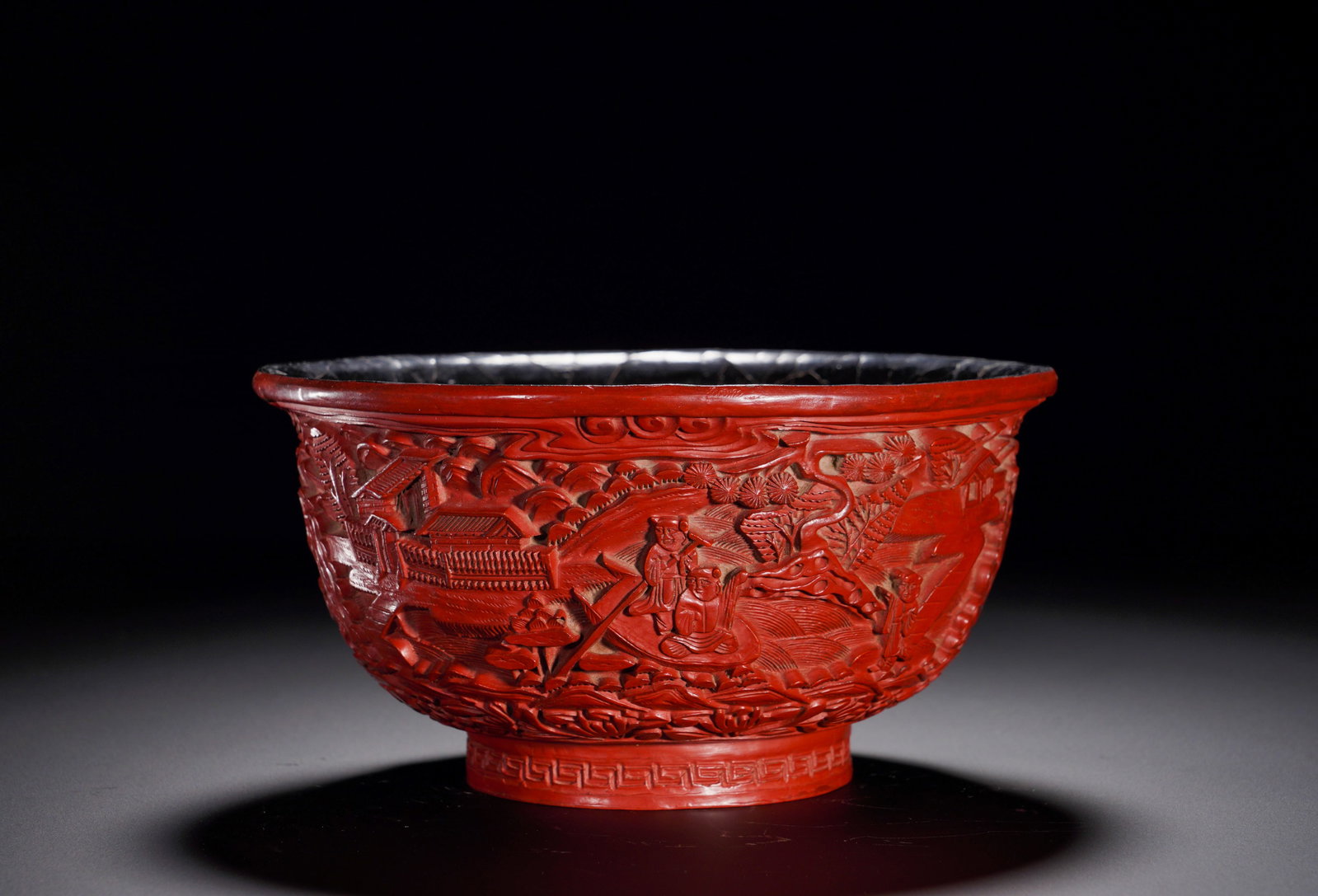 QING DYNASTY RED LACQUERWARE BOWL WITH LANDSCAPE AND FIGURE PATTERNS: Height:8cm (3.15in)Width:16cm (6.30in)Weight:270g(0.60lb)Qing Dynasty carved red lacquer bowl with landscape and figures.Wide opening curved wall. The exterior is carved with layered mountain