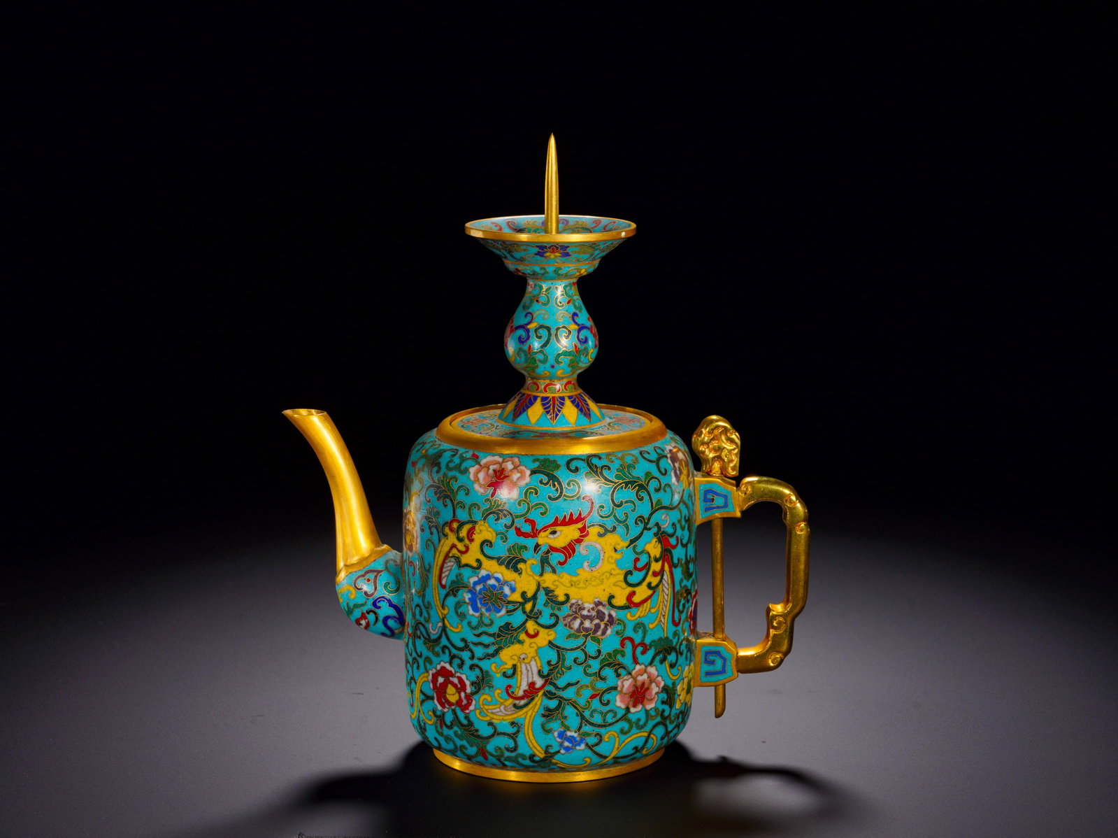 QING DYNASTY COPPER CLOISONNE ENAMEL PHOENIX PATTERN EWER: Height:22cm (8.66in)Width:18cm (7.09in)Weight:910g(2.01lb)Qing Dynasty gilt bronze cloisonn?? ewer with phoenix motif.Cylindrical body with removable candlestick-shaped lid holder. Turquoise enamel gr