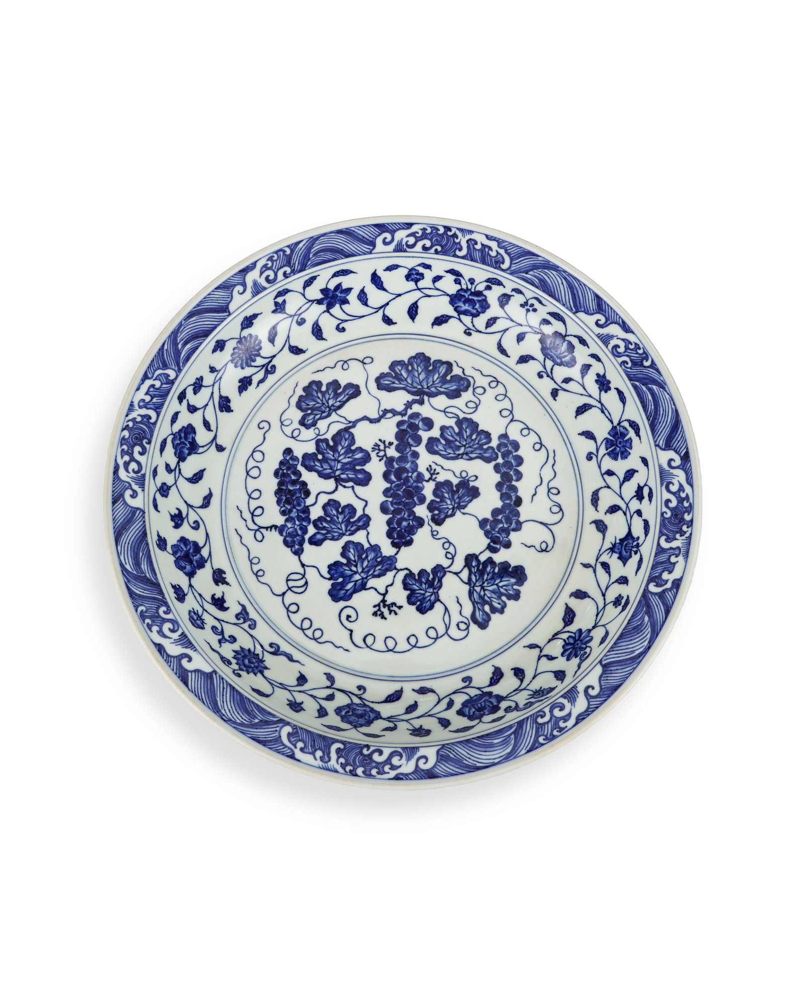 A BLUE AND WHITE PLATE WITH SEA AND GRAPE PATTERNS BY YONGLE OF THE MING DYNASTY: H:6.5cm W:39.2cm This is an imperial large blue-and-white plate of Ming Dynasty, with wide flared mouth and shallow belly supported by neat ring foot. It is covered with glossy pure white glaze,