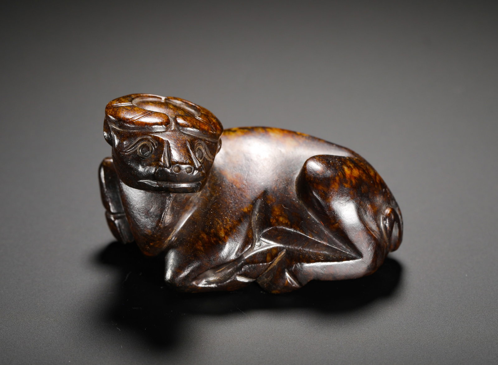 HAN DYNASTY HETIAN JADE RECLINING OX: Height:4cm (1.57in) Width:8cm (3.15in) Weight:206g(0.45lb)Antique carved jade recumbent ox hand ornament, hollowed from single whole jade. The ox squats in resting posture with coiled horns, concise p