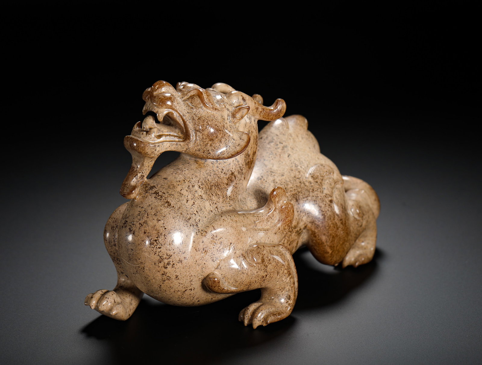 HAN DYNASTY HETIAN JADE AUSPICIOUS BEAST: Height:10cm (3.94in) Width:16cm (6.30in) Weight:990g(2.18lb)Han Dynasty solid jade carved auspicious beast ornament. Recumbent sacred tiger with curled horns and spiral tail, full grey-white burial pa