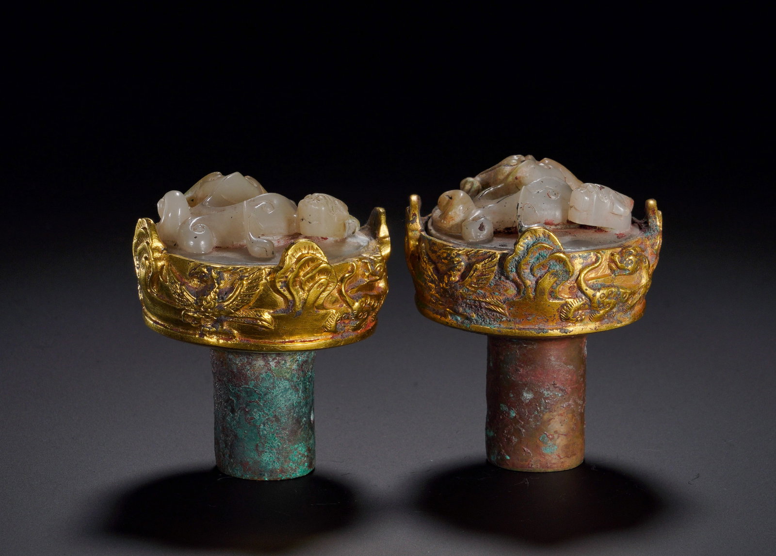 HAN DYNASTY BRONZE GILDED WITH GOLD AND INLAID WITH JADE CHI DRAGON STAFF HEAD: Height:7.2cm (2.83in)Width:6.2cm (2.44in)Weight:570g(1.26lb)Cylindrical bronze shanks for inserting cane shafts. Gilt bronze rims are embossed with phoenix and mythical beasts. White jade plaques are 