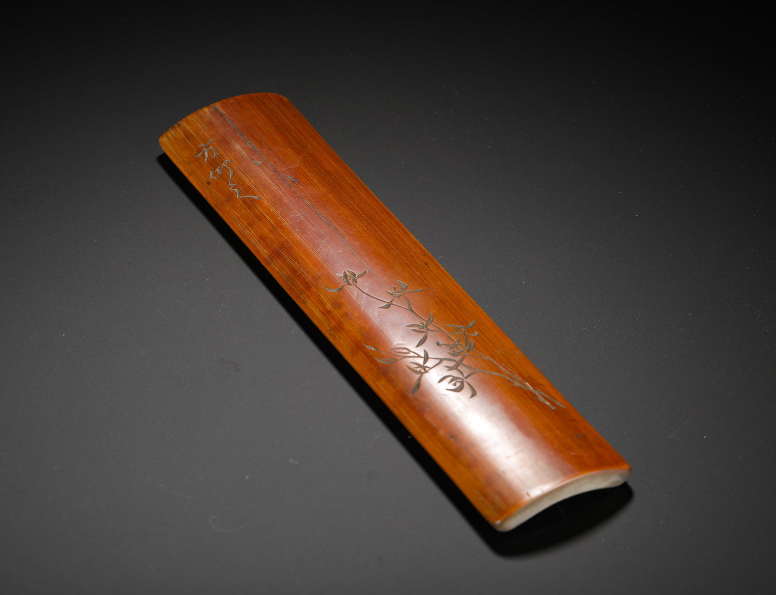 QING DYNASTY BAM-CARVED ORCHID PATTERN ARMREST: Height:23.5cm (9.25in) Width:6cm (2.36in) Weight:90g(0.20lb)Vintage bamboo carved arm rest with orchid engraving, simple elegant floral design, desk tool to support wrist during calligraphy