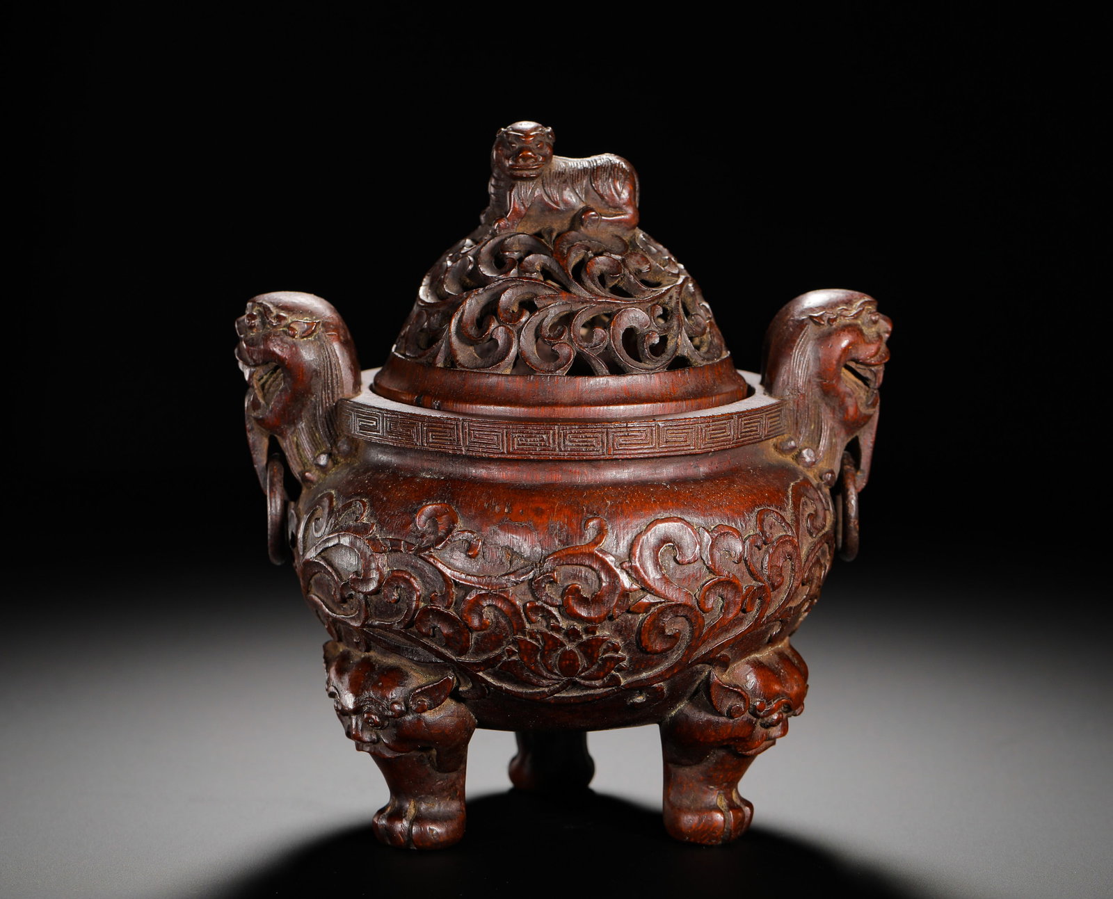 BAMBOO CARVINGS OF FLORAL AND ANIMAL-EAR THREE-LEGGED INCENSE BURNERS FROM THE QING DYNASTY: Height:16cm (6.30in) Width:14cm (5.51in) Weight:330g(0.73lb)Carved bamboo three-legged incense burner with peony scrolls on body, beast-head ring handles, hollowed-out scrolling grass cover topped wit