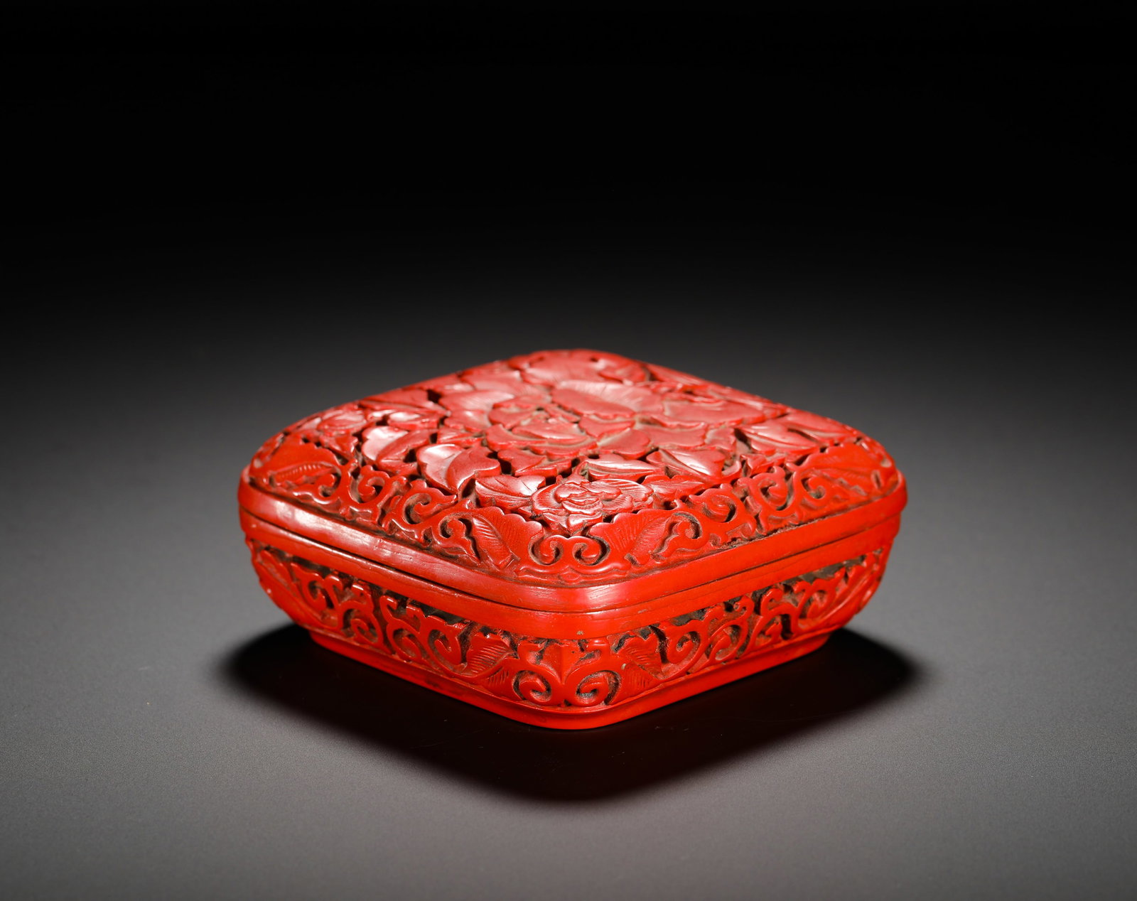 QING DYNASTY RED PEONY FLOWER SEAL PASTE BOX: Height:4cm (1.57in) Width:10cm (3.94in) Weight:150g(0.33lb)Carved red lacquer square ink paste box fully carved with peony scrolls on the lid, scrolling grass patterns on sides, inscribed "Made in She