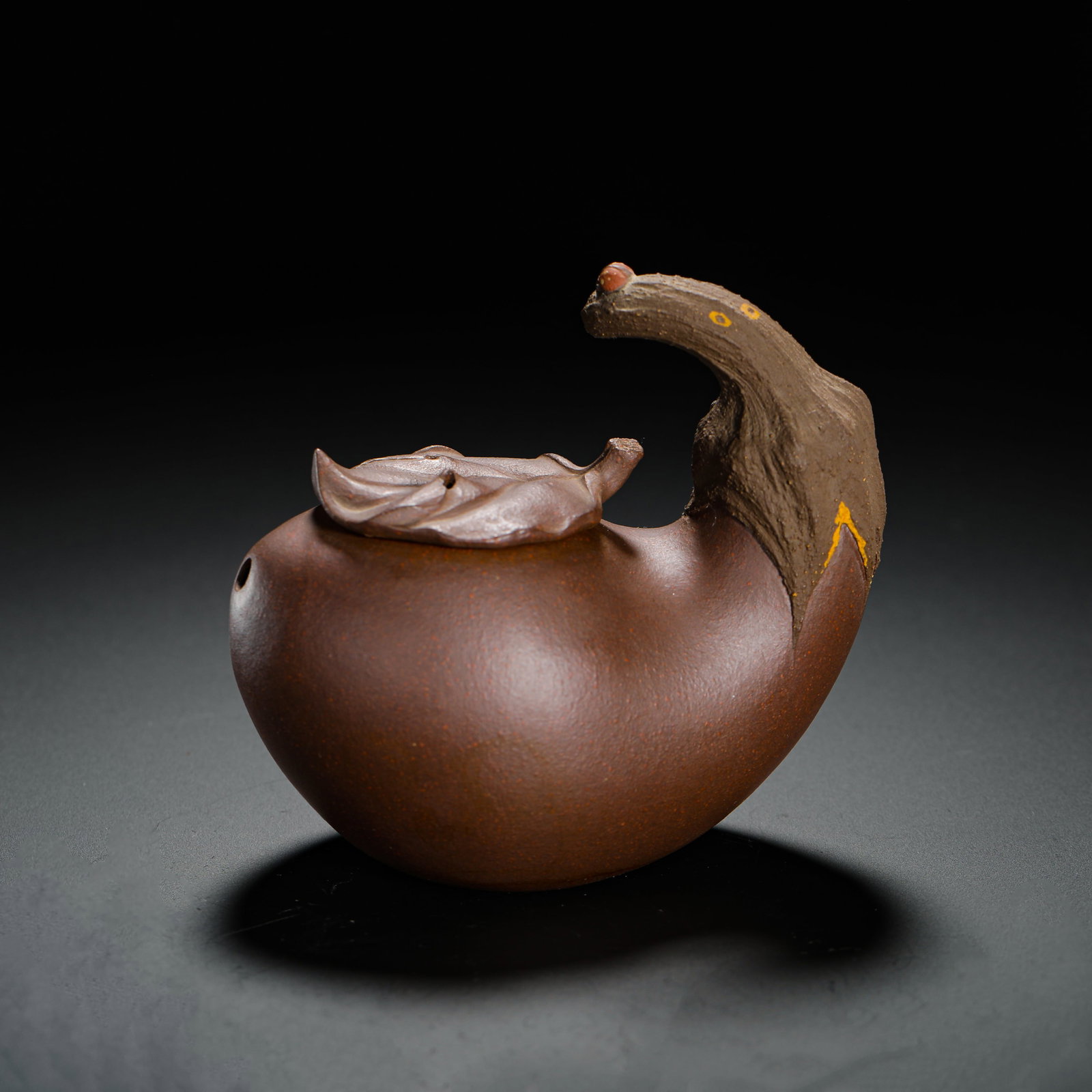 HU RENJIE PURPLE CLAY TEAPOT: H:8cm W:10cm Weight:150g Classic fruit biomorphic floral teapot made of grainy aged purple clay, fully sculpted in the shape of an eggplant. Plump oval body with small side spout; large curved eggplan