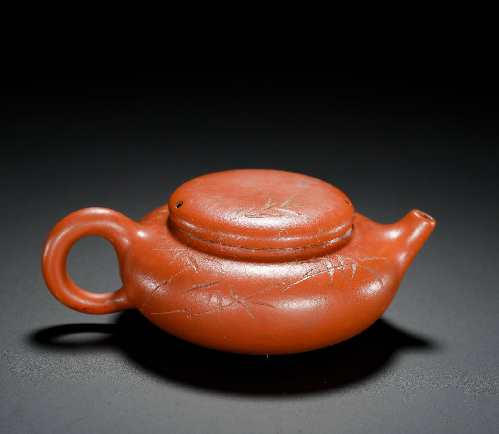 ZHU NI FLAT BELLY BAMBOO-CARVED SMALL STONE LADLE PURPLE CLAY TEAPOT: H:4cm W:11cm Weight:100g Miniature Shipiao teapot crafted from fine natural vermilion clay with bright ruddy tone. Wide flat belly with soft minimalist lines, short straight spout delivers clean water