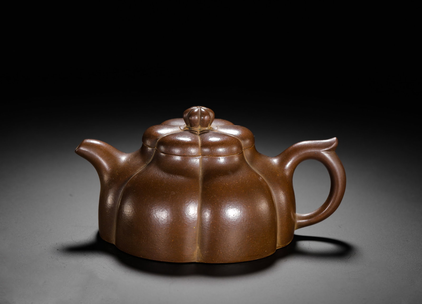 WANG YINCHUN SUNFLOWER PETAL RIBBED PURPLE CLAY TEAPOT: H:8cm W:16cm Weight:320g Classic ribbed Zisha teapot crafted from smooth aged purple clay. The whole body takes the shape of six sunflower petals, with rib lines running vertically from base to lid. F