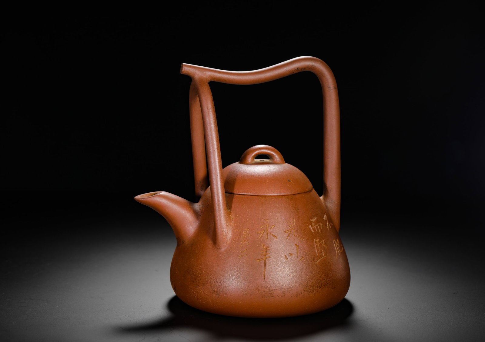 CHEN MANSHENG DONGPO HANDLE PURPLE CLAY TEAPOT: H:18cm W:18cm Weight:710g Classic Dongpo baili plain teapot crafted from fine natural vermilion clay. Inverted pear-shaped triangular body with distinctive bent double-post bail handle of elegant flow