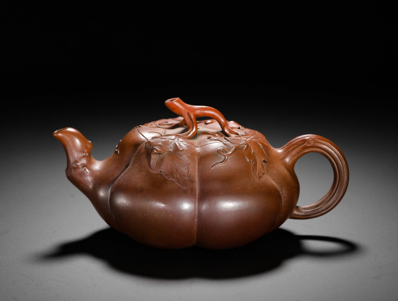 ZHU NI PUMPKIN VINE PURPLE CLAY TEAPOT: H:8cm W:26cm Weight:270g Classic biomorphic ribbed floral teapot of natural vermilion clay. Even pumpkin rib segments with plump smooth lines; spout shaped as melon stem, lid knob twisted melon vine, 
