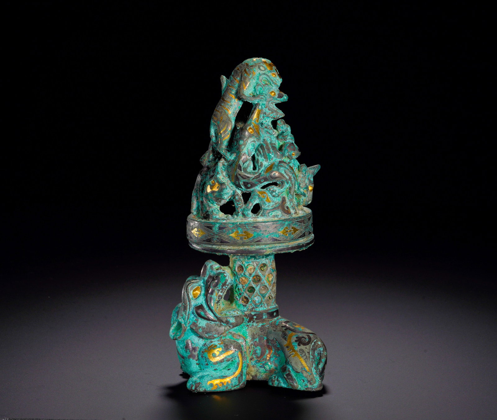 HAN DYNASTY BRONZE INLAID GOLD AND SILVER AUSPICIOUS BEAST BOSHAN-STYLE INCENSE BURNER: Height:17cm (6.69in)Width:8.5cm (3.35in)Weight:1100g(2.42lb)Han Dynasty bronze incense stand with gold and silver inlay.A crouching mythical beast serves as base support decorated with inlaid scroll p