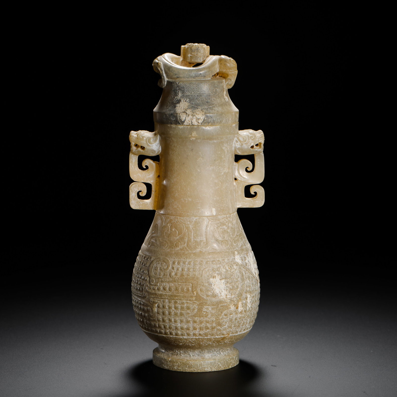 HAN DYNASTY HETIAN JADE BEAST-EAR CAP BOTTLE: H:27cm W:7.3cm Weight:380g Han Dynasty jade display vase with double dragon cloud-shaped handles, fully carved grain patterns and extensive soil patina, an ancient ritual jade ornament.