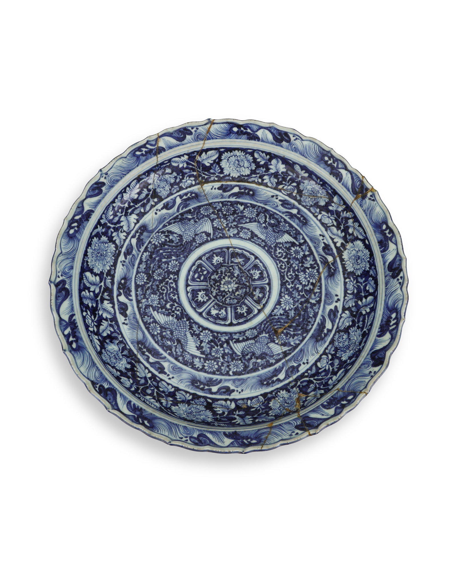 YUAN DYNASTY BLUE AND WHITE COILED FLOWER PHOENIX-PATTERNED RHOMBUS-MOUTHED LARGE PLATE (REVISED): H:8cm W:46.5cm Blue-and-white large lobed-rim plate of Yuan or Ming style, wavy petal-shaped rim, wide folded flange and shallow curved belly. The interior is divided into multiple concentric bands of