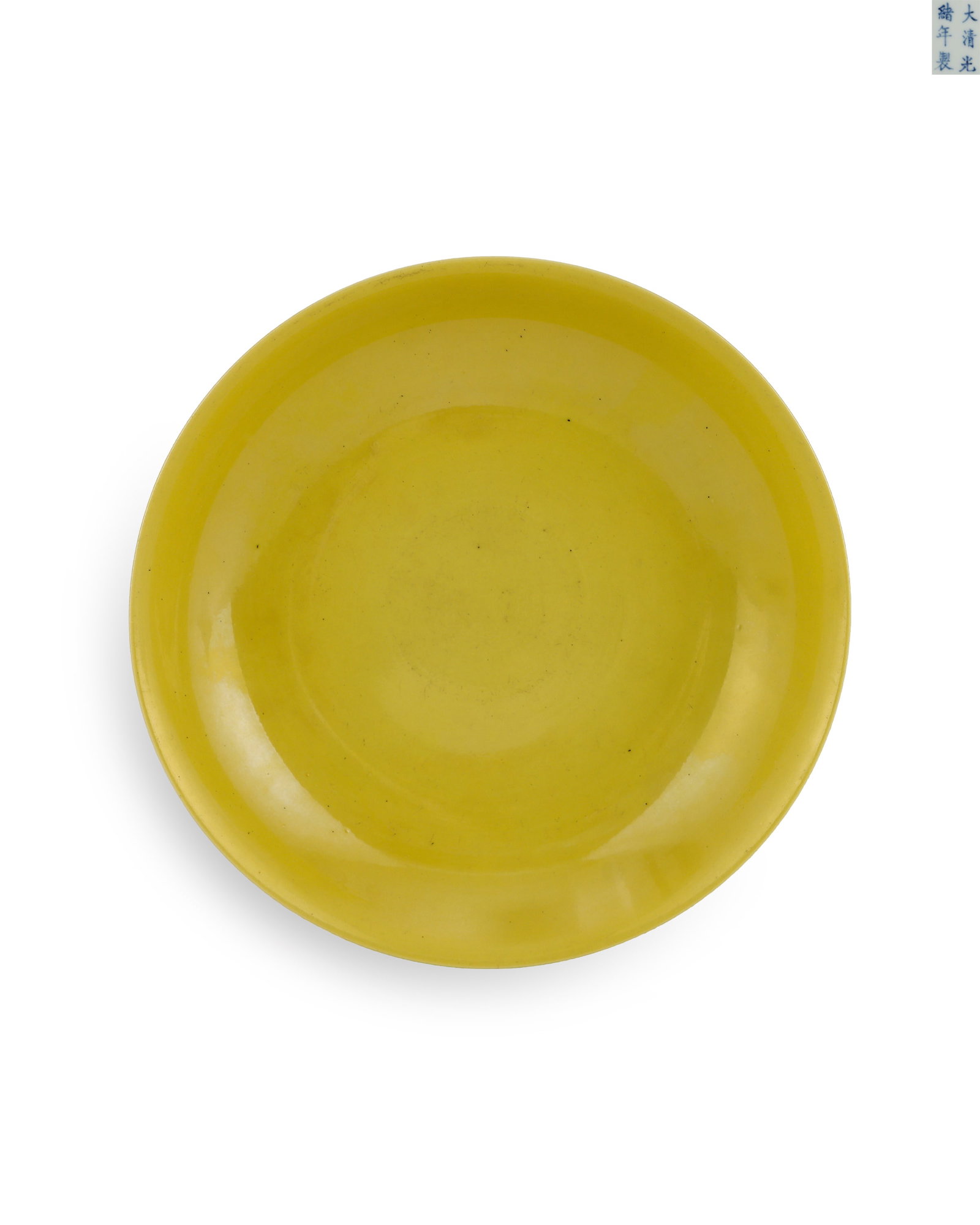 A BRIGHT YELLOW GLAZED PLATE FROM THE REIGN OF EMPEROR GUANGXU OF THE QING DYNASTY: H:3.7cm W:18.5cm Official yellow glaze plate of Guangxu reign, Qing Dynasty, wide flared mouth and shallow belly with neat ring foot. The whole interior is fully covered with tender imperial yellow gl