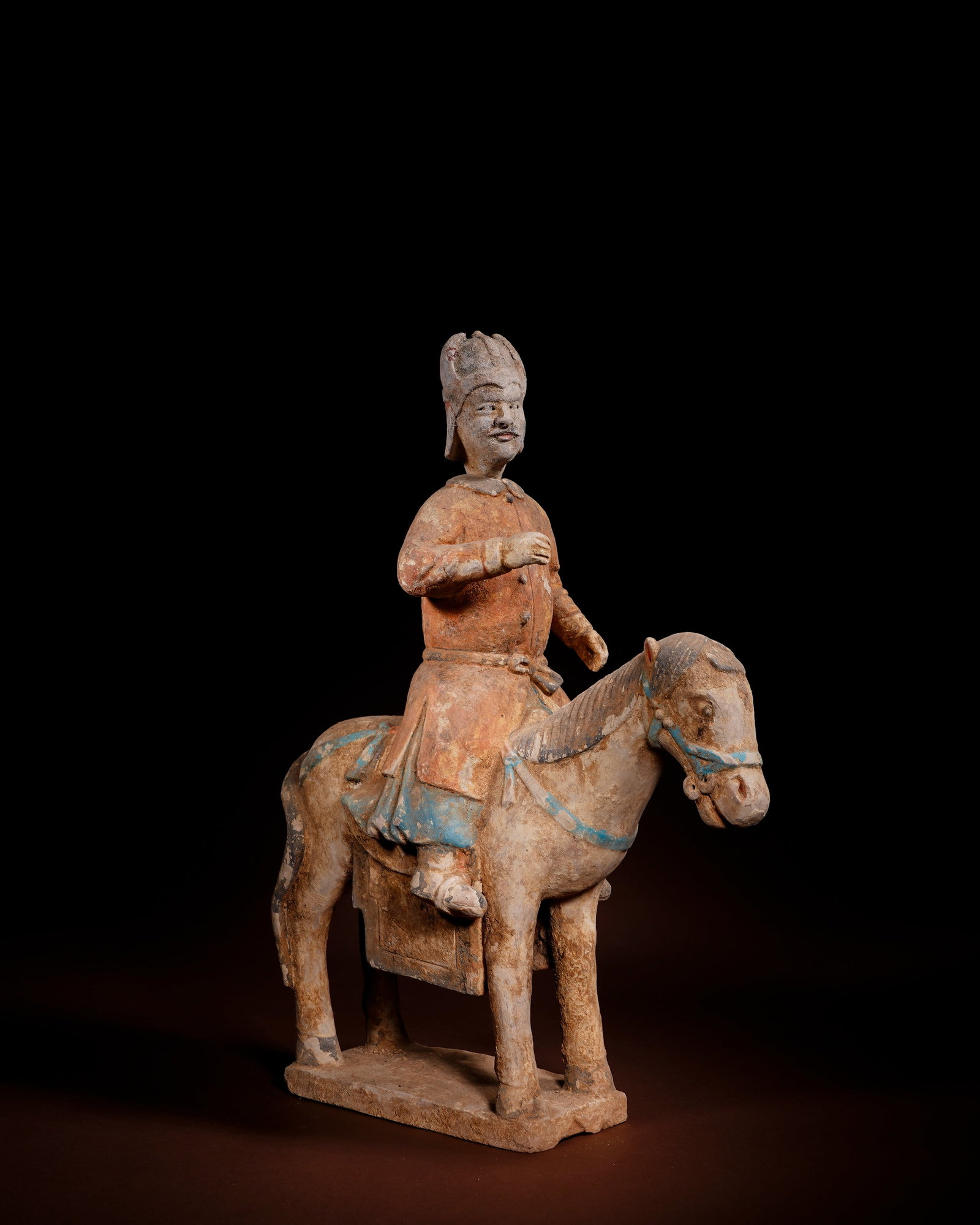 PAINTED POTTERY FIGURINES OF OFFICIALS ON HORSEBACK FROM THE MING DYNASTY: L:27.5cm H:37cm This painted pottery equestrian official figurine of Ming Dynasty is made of white clay, painted with mineral pigments and fired as an integrated piece with rectangular base.The figure