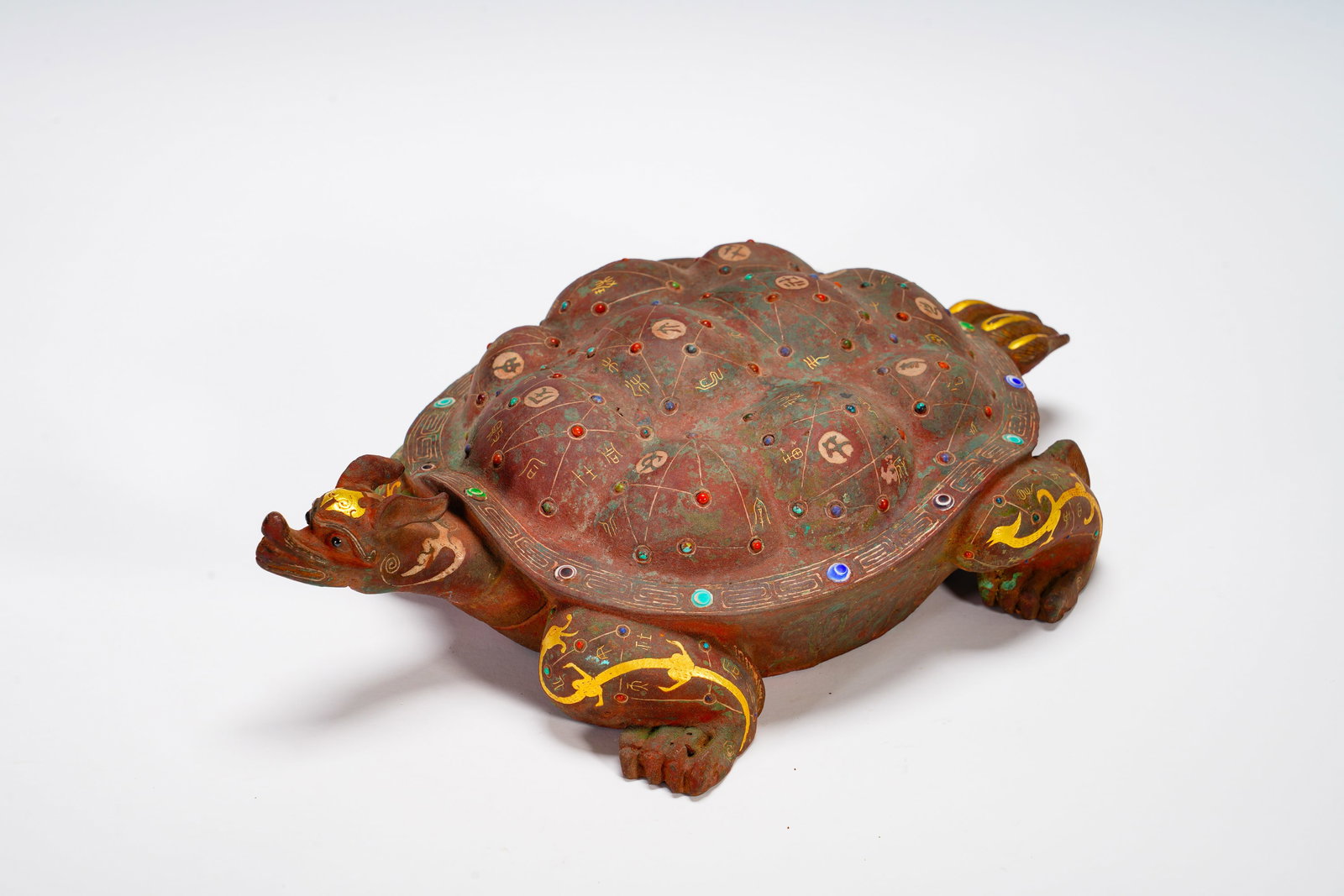 BRONZE INLAID WITH GOLD ASTRONOMICAL STAR TORTOISE: Long:17cm (6.69in) Width:26cm (10.24in) Weight:1570g(3.46lb)The bronze relic shaped as dragon-headed turtle deity. Surface decorated with golden star chart lines, colorful gemstone stars, inscribed st