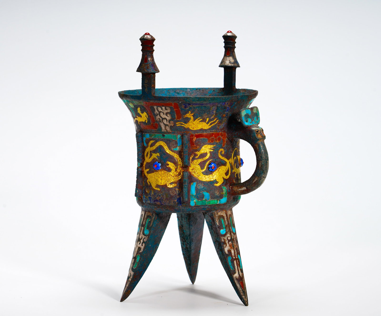 SHANG DYNASTY BRONZE INLAID WITH A DRAGON PATTERN: Height:29cm (11.42in) Width:17cm (6.69in) Weight:1970g(4.34lb)Classic Shang tripod drinking vessel fitted with upright posts and beast handle. Surface decorated with golden interlaced dragon and deer 