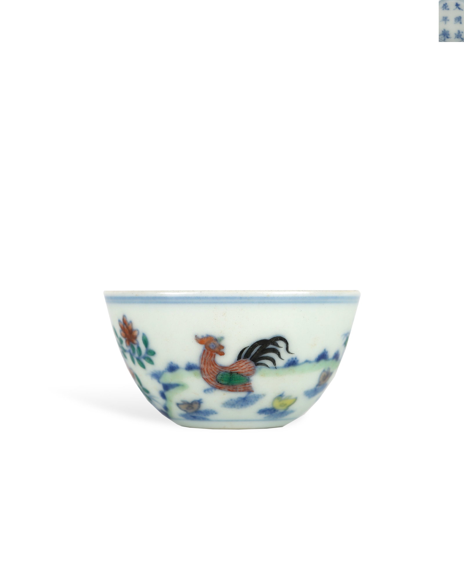 CHENGHUA DOUCAI CHICKEN CUP OF THE MING DYNASTY: H:3.1cm W:5.8cm Small open-mouthed doucai wine cup with flat base marked "Made in Chenghua Reign of Great Ming". Its outer wall is decorated with a family of chickens painted with underglaze blue and 