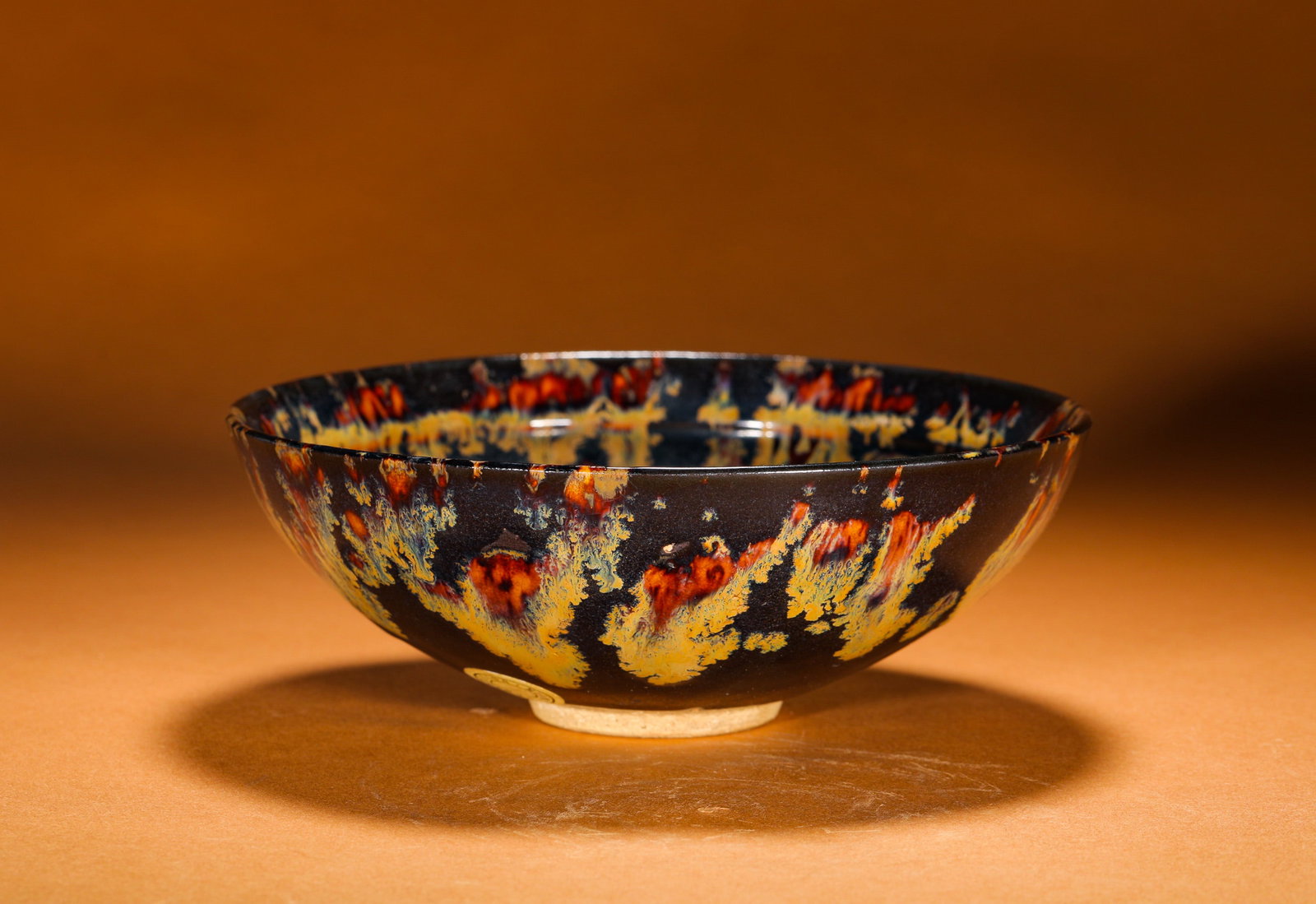 JIZHOU KILN TORTOISESHELL SPOTTED TENMOKU BOWL: Height:6cm (2.36in)Diameter:16.5cm (6.50in)Weight:300g(0.66lb)Jizhoukilntortoise-shellspottedtemmokuteabowl.Foldedrim, shallowtaperingbellyandsmallfootwithoff-whiteclayexposedatbase.Fullycoveredinblac