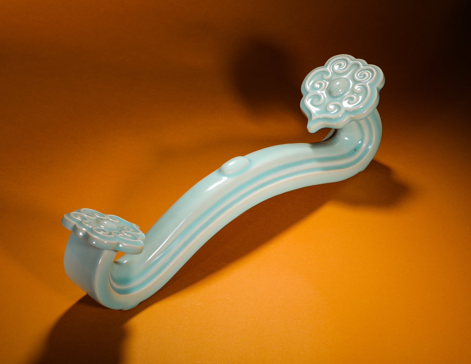SKY BLUE GLAZED RUYI CLOUD PATTERN PORCELAIN RUYI: Height:14cm (5.51in)Width:47cm (18.50in)Weight:1850g(4.08lb)Celadonsky-blueporcelainruyiornamentwithcloudmotif.ClassicS-shapedcurvedbody, bothendssculptedintoembossedcloudruyiheadswithfullswirlingscro
