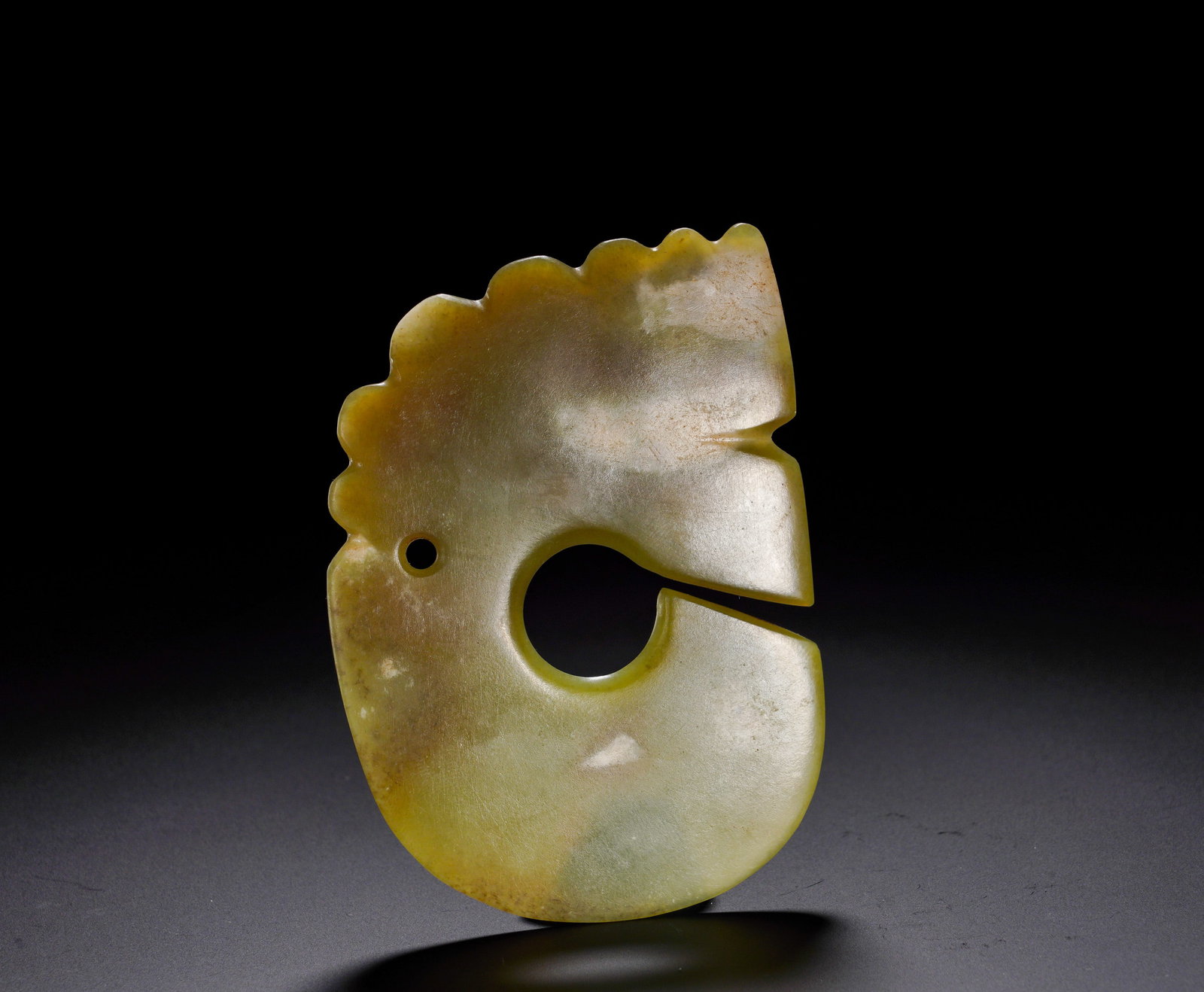 RED MOUNTAIN CULTURE YELLOW JADE TOOTHED EDGE JADE DISC: Height:9.5cm (3.74in) Width:7cm (2.76in) Weight:60g(0.13lb)The yellow jade ring with opening and serrated edge, suspension hole on one side. Serpentine rim motifs prevailed in prehistoric northern rit
