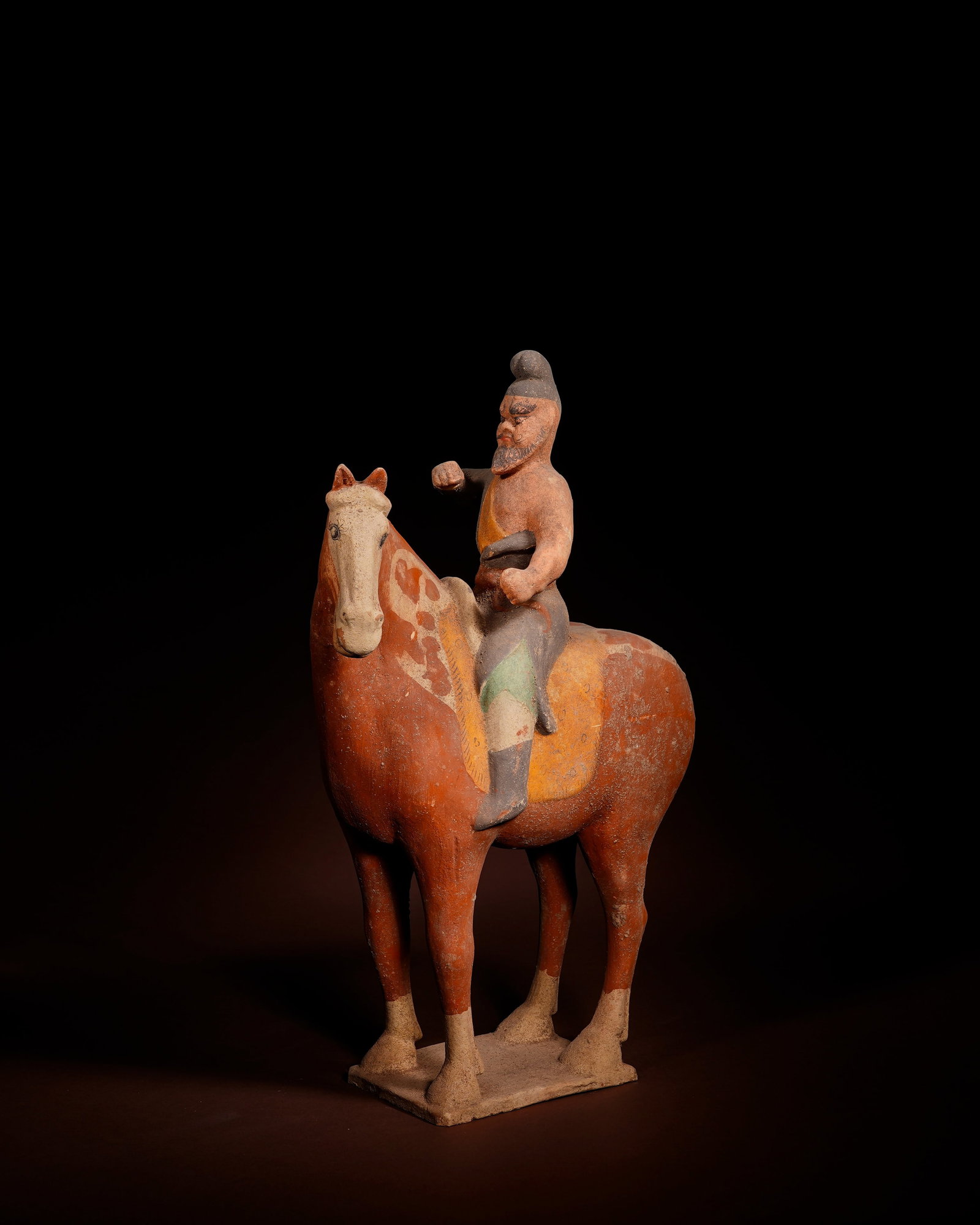 TANG DYNASTY PAINTED TERRACOTTA WARRIORS RIDING HORSES: L:23.5cm H:36.5cm This painted pottery equestrian warrior figurine of Tang Dynasty is molded separately from clay then assembled, integrated with square base, decorated with red, yellow and green mine